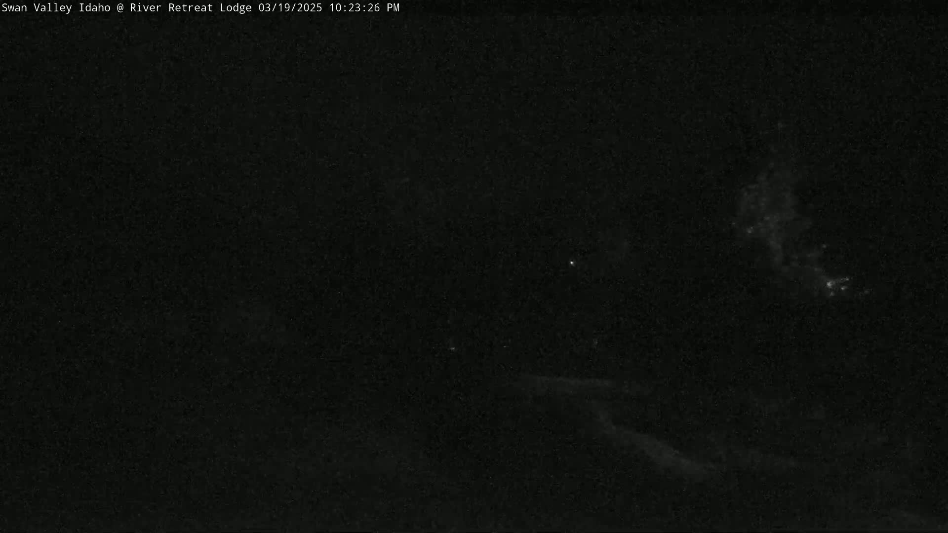 A nighttime outdoor scene shows a dark sky with faint lights possibly from distant stars or light pollution.