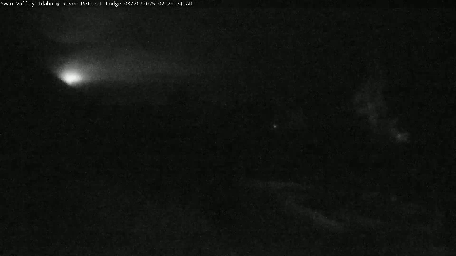 A bright light streaks across a dark night sky.