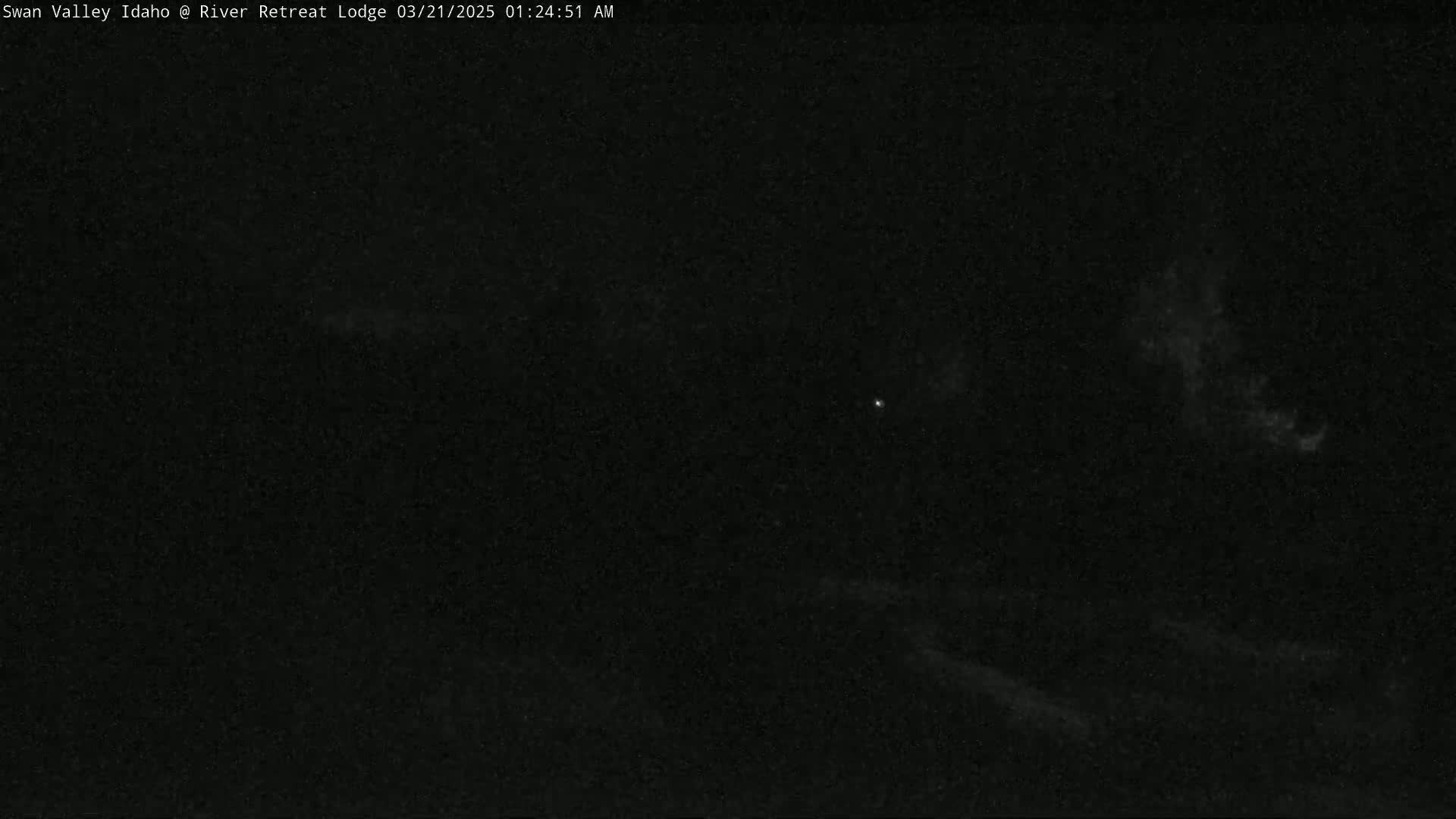 A nighttime, dark sky shows faint clouds and a few stars.