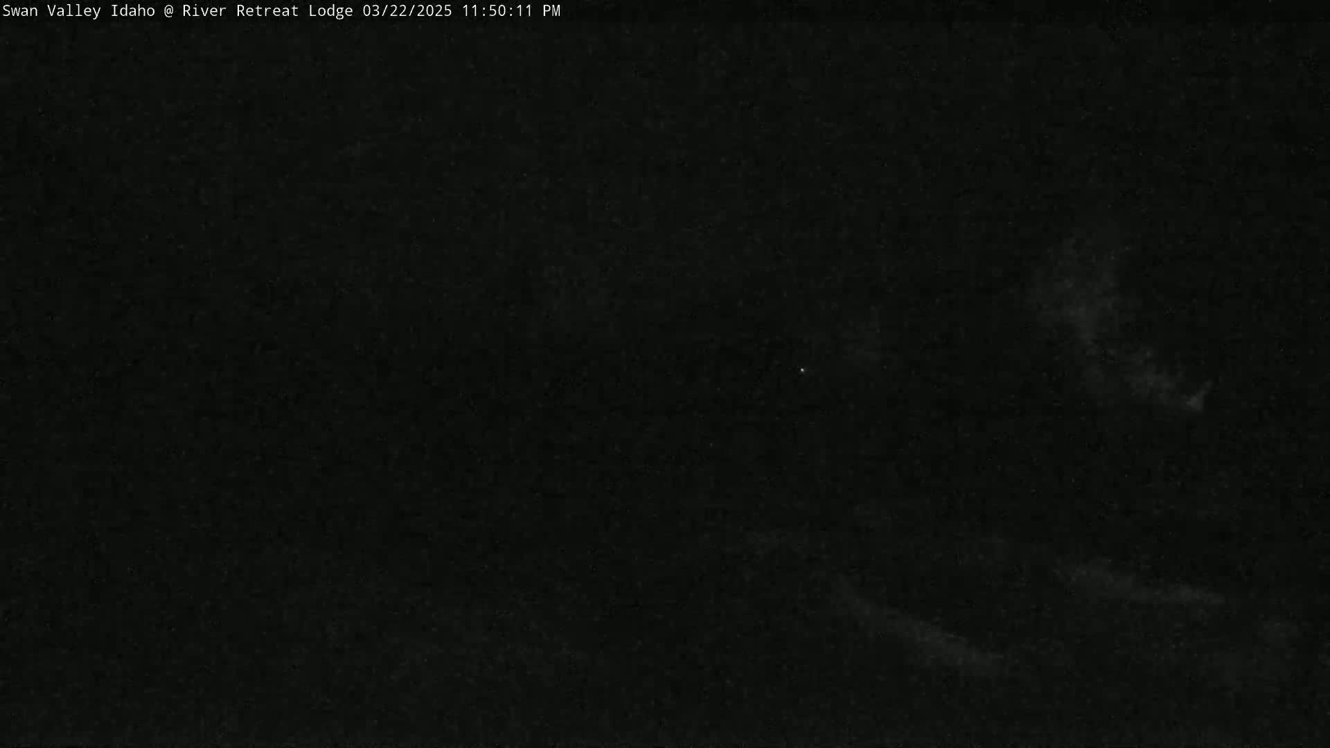 A mostly clear night sky shows faint clouds and stars.