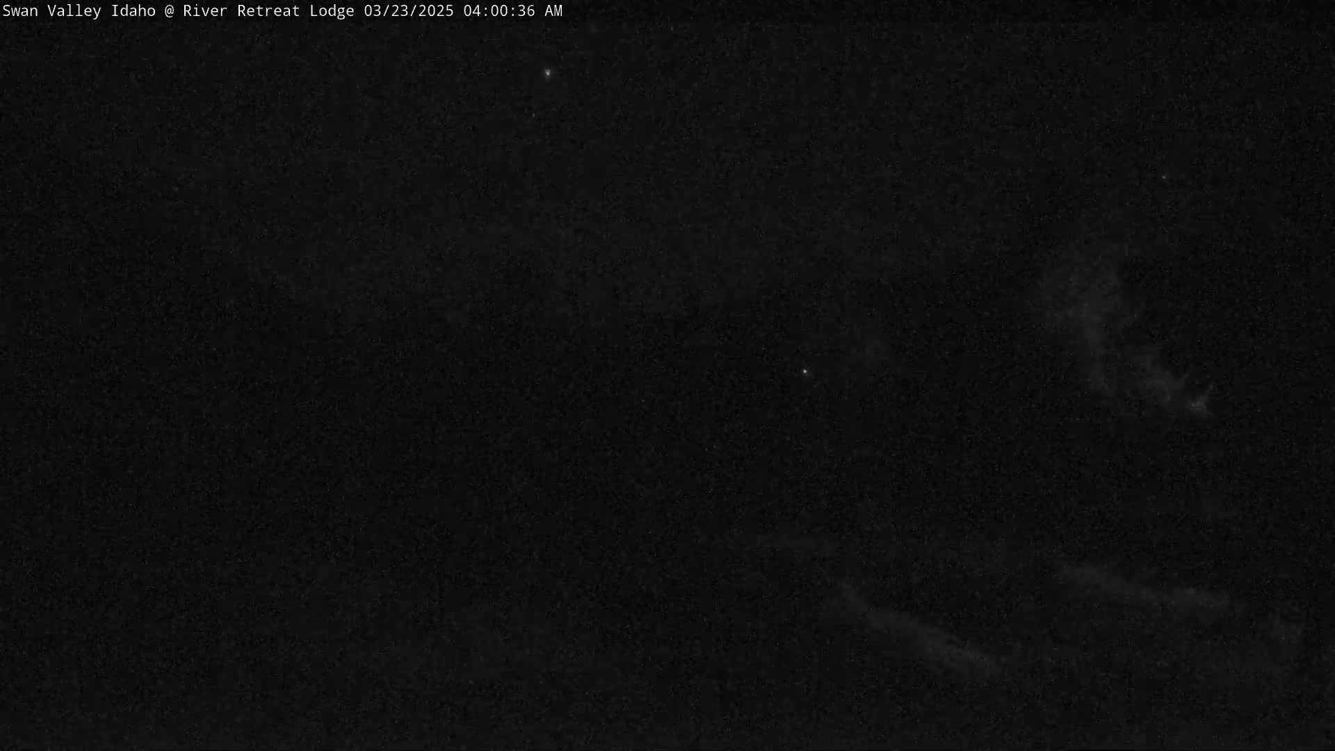 A nighttime outdoor scene shows a dark sky with a few faint stars and some light cloud cover.