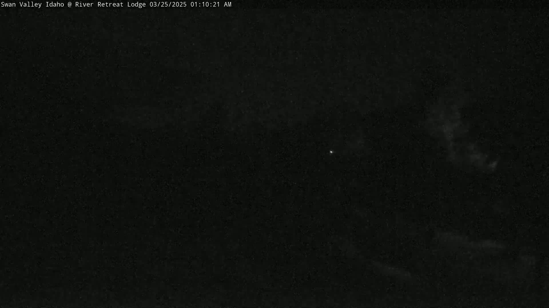 A dark, nighttime scene shows a few faint clouds and a single, distant light.