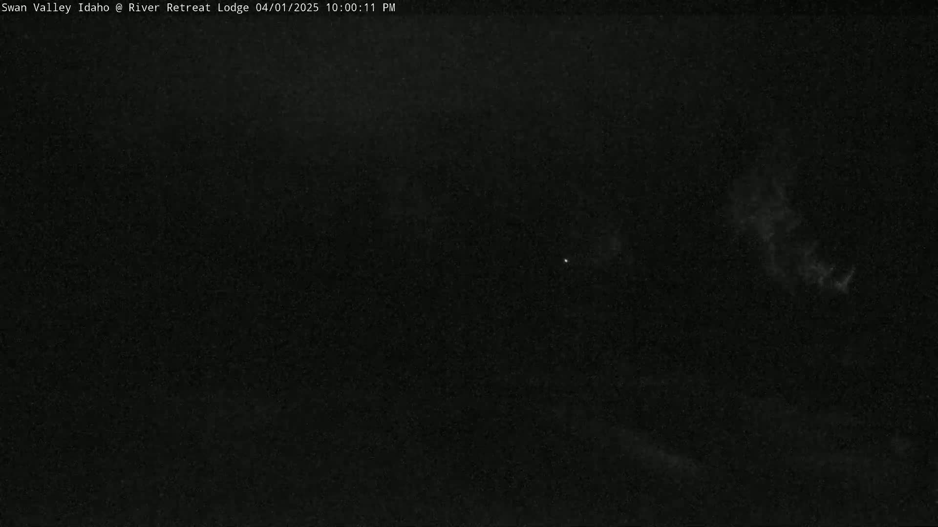 A nighttime, dark sky with a few faint clouds and a single bright star is visible.