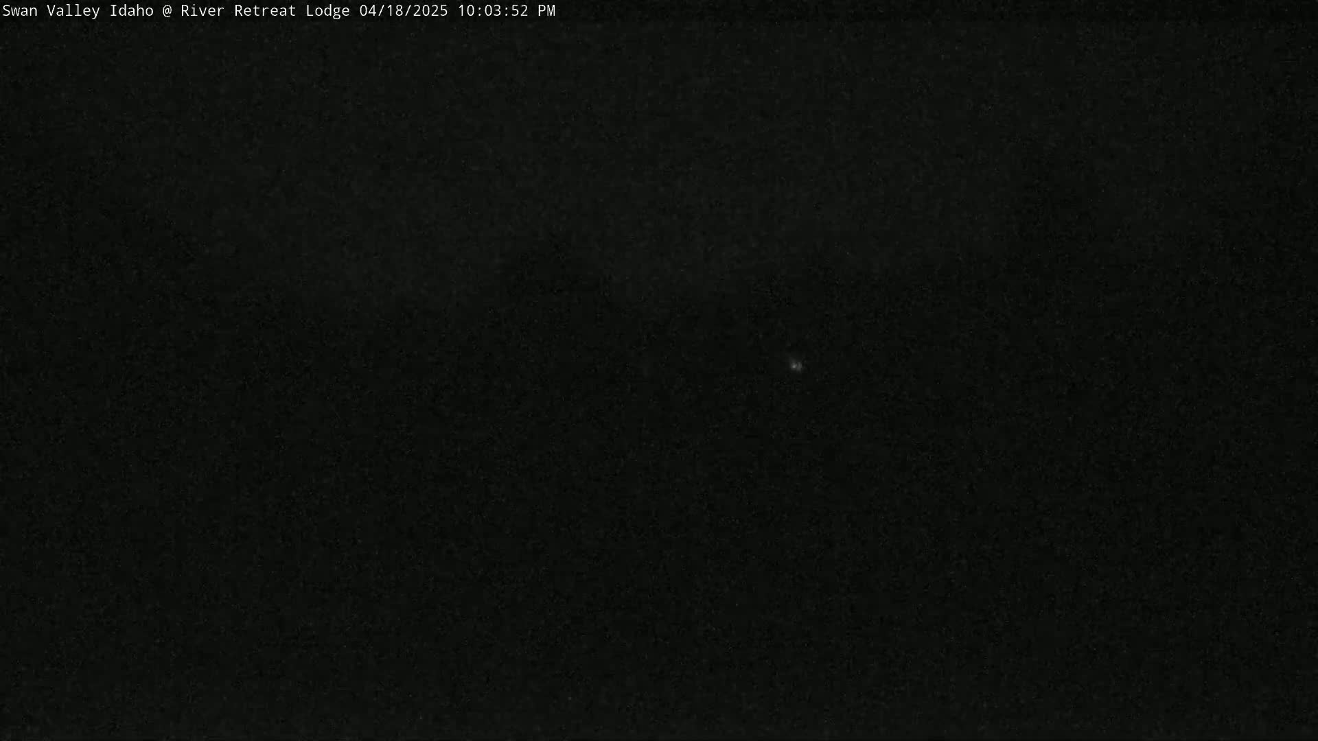 A nearly entirely black image shows a night sky with a single, faint light source.