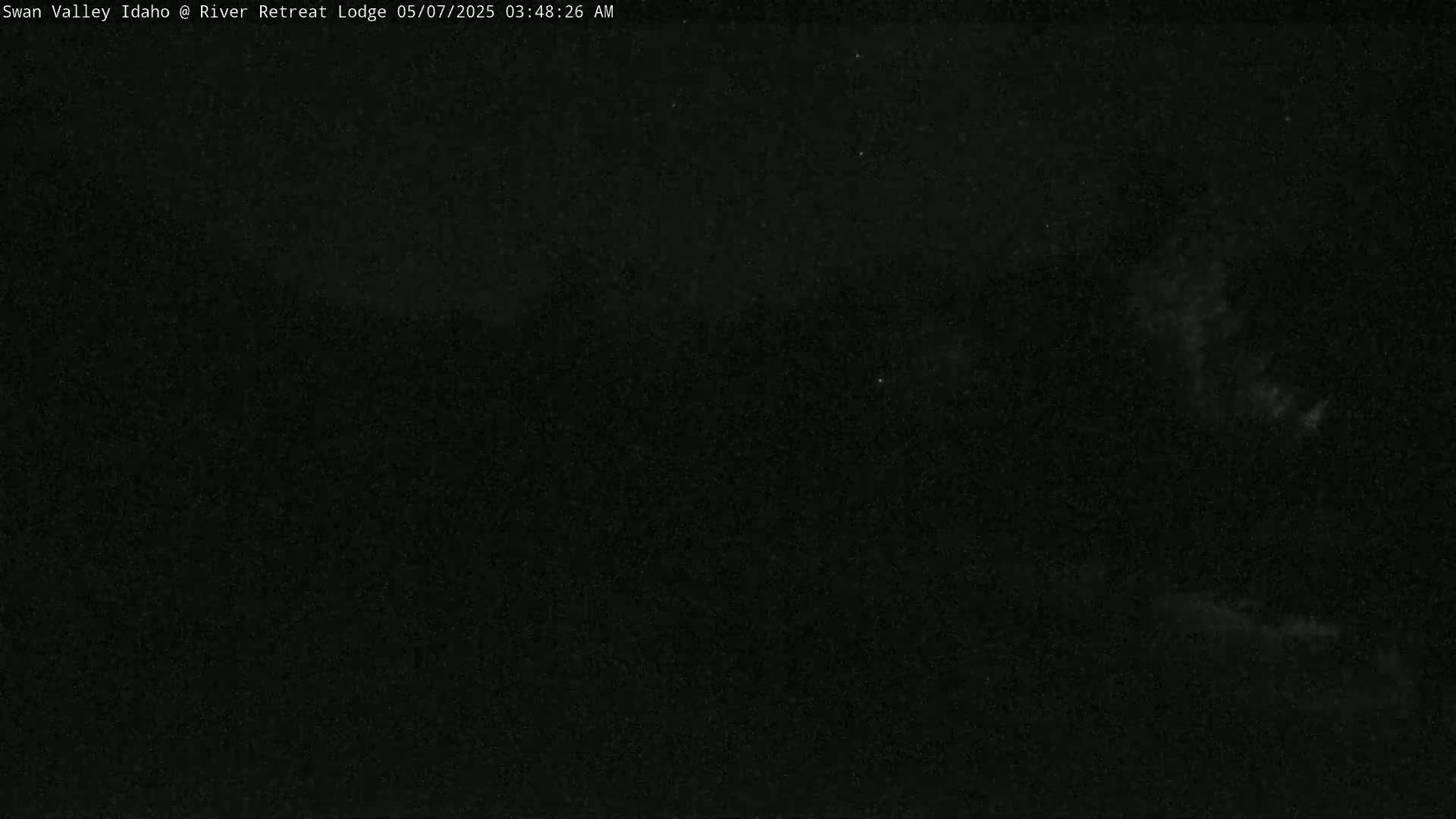 A mostly dark, nighttime outdoor scene shows a few faint clouds in a dark sky.