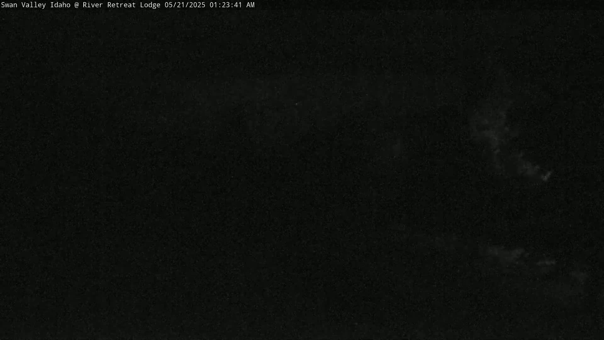 A mostly dark image shows a night sky with some faint clouds.
