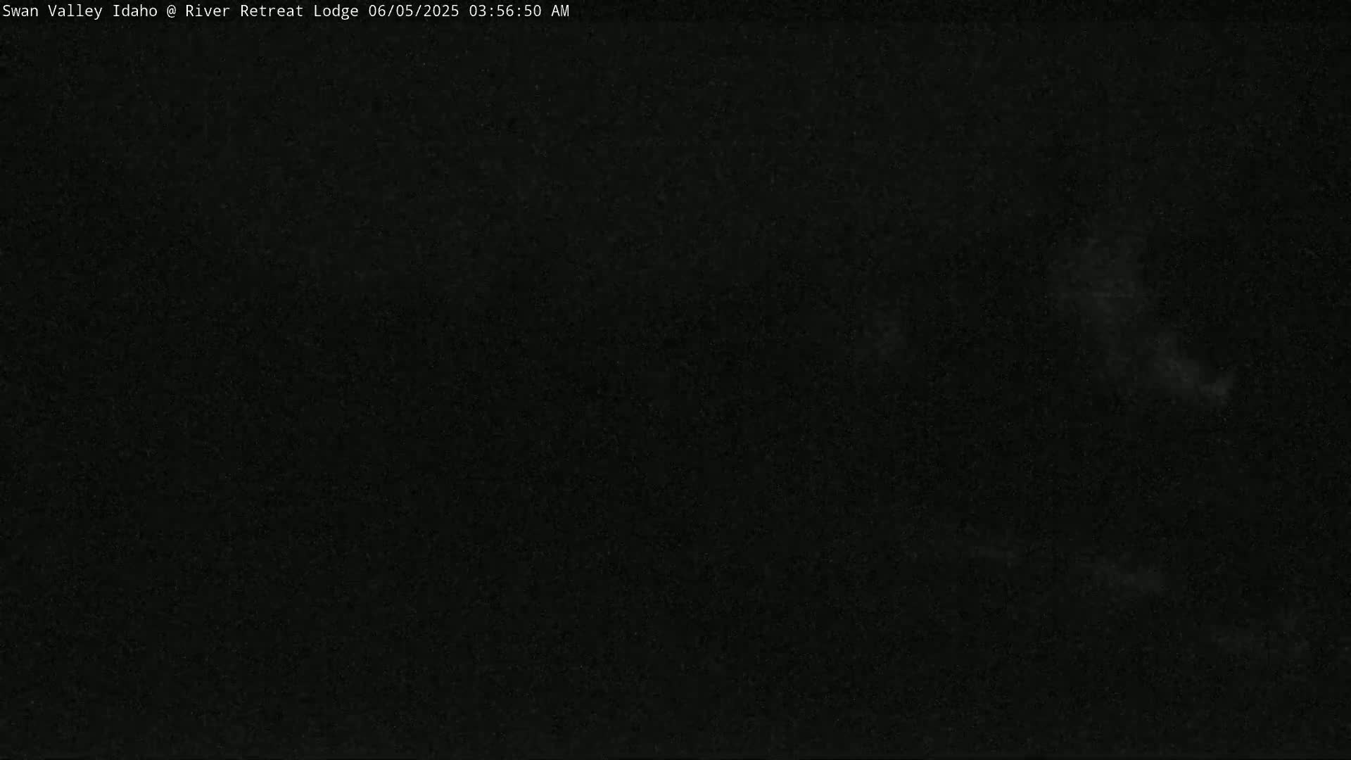 A dark, nighttime image shows a mostly black sky with some faint, light gray clouds.