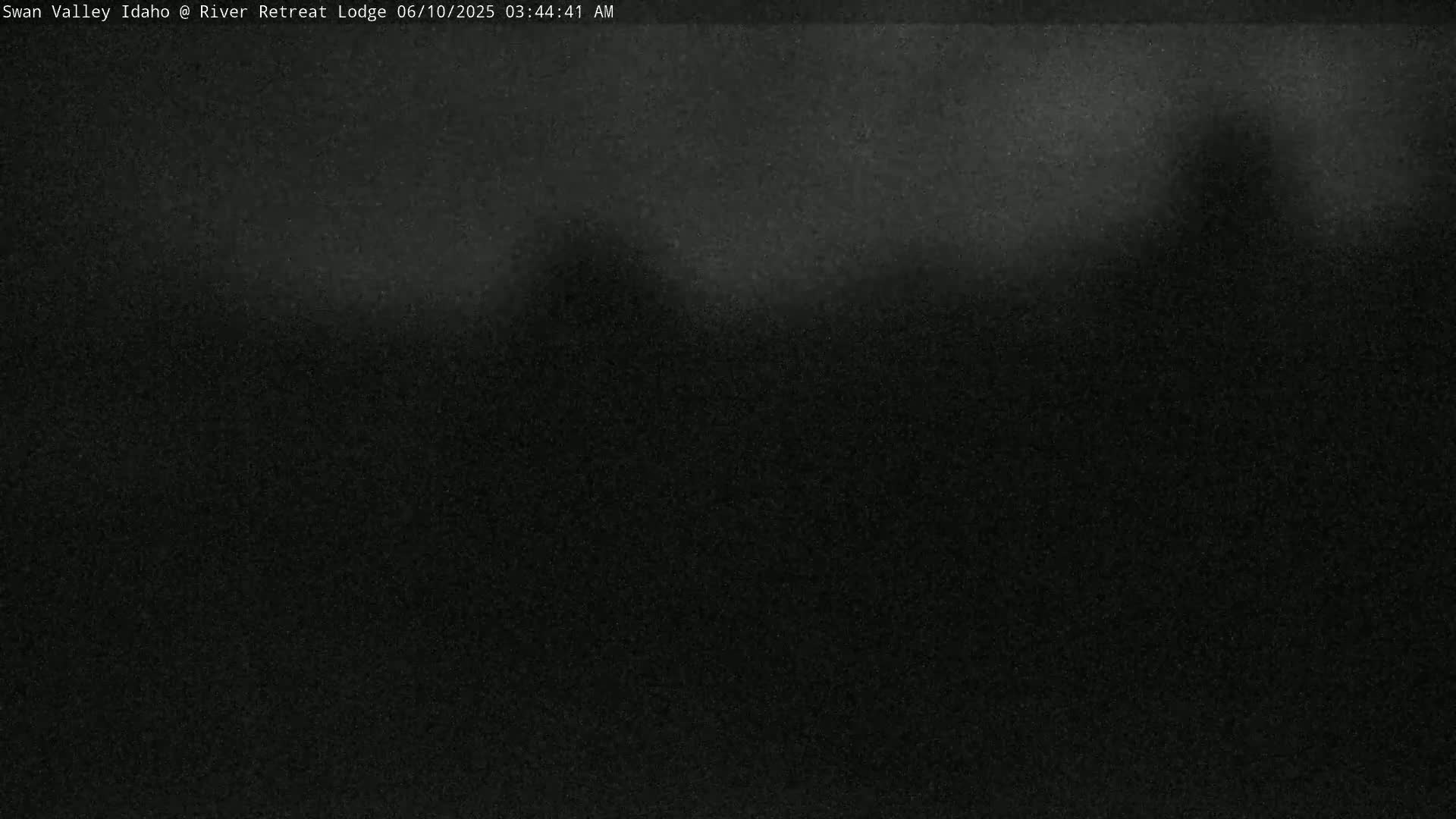 A dark, grainy image shows a mostly featureless, dark landscape under a night sky.