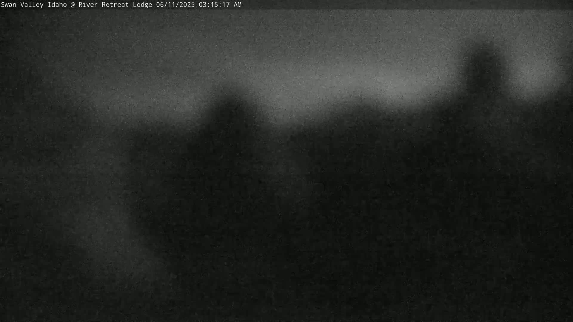 A dark, blurry image shows an indistinct landscape under a hazy, possibly foggy, sky.