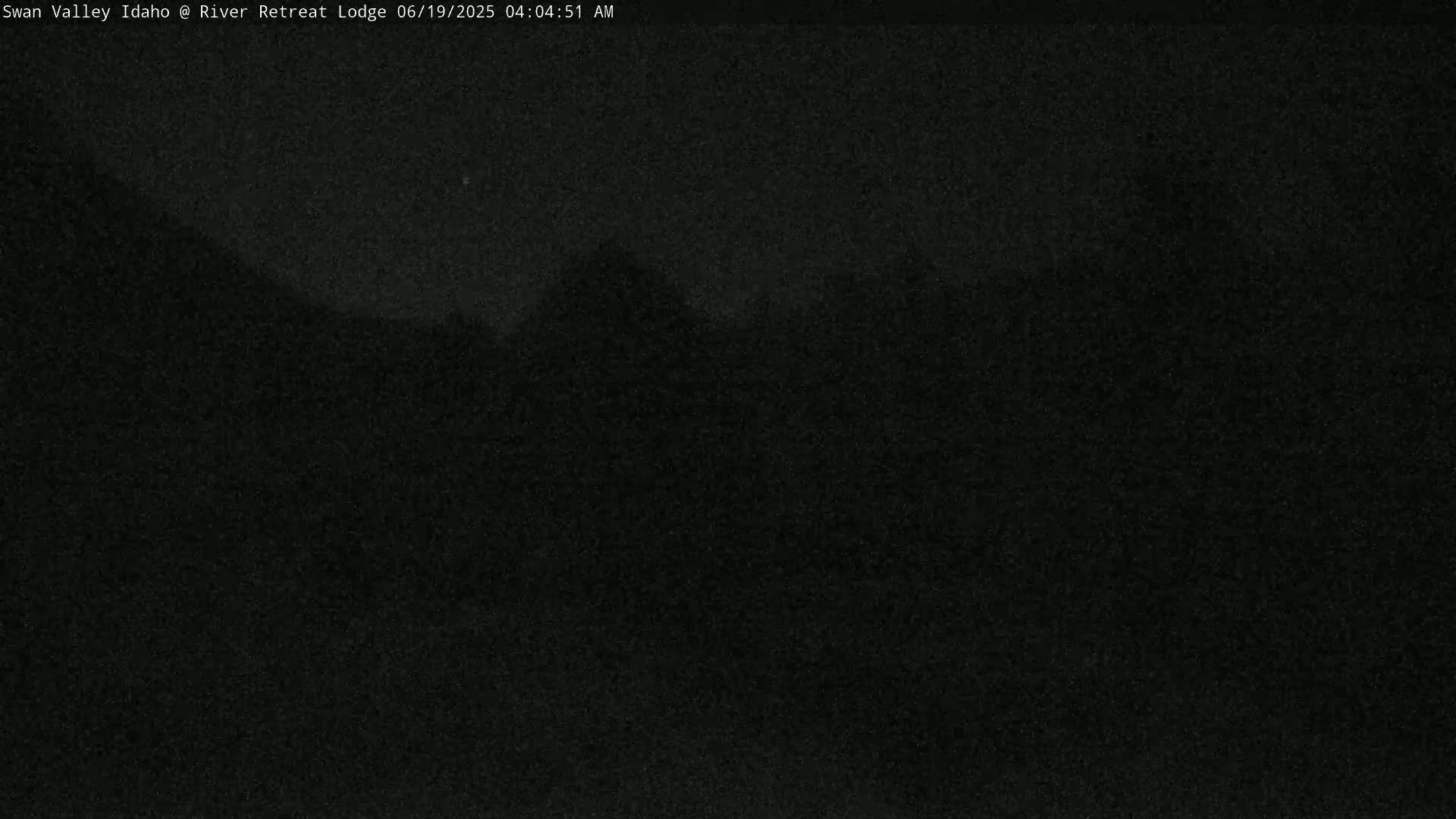 A dark, nighttime outdoor scene shows a mostly black landscape under a mostly clear sky.