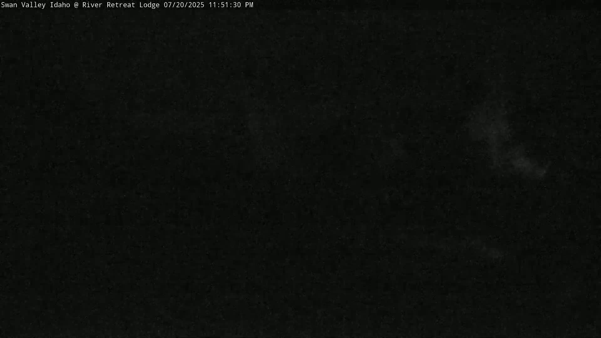 A dark, nighttime image shows a mostly clear sky with a few faint, light patches.