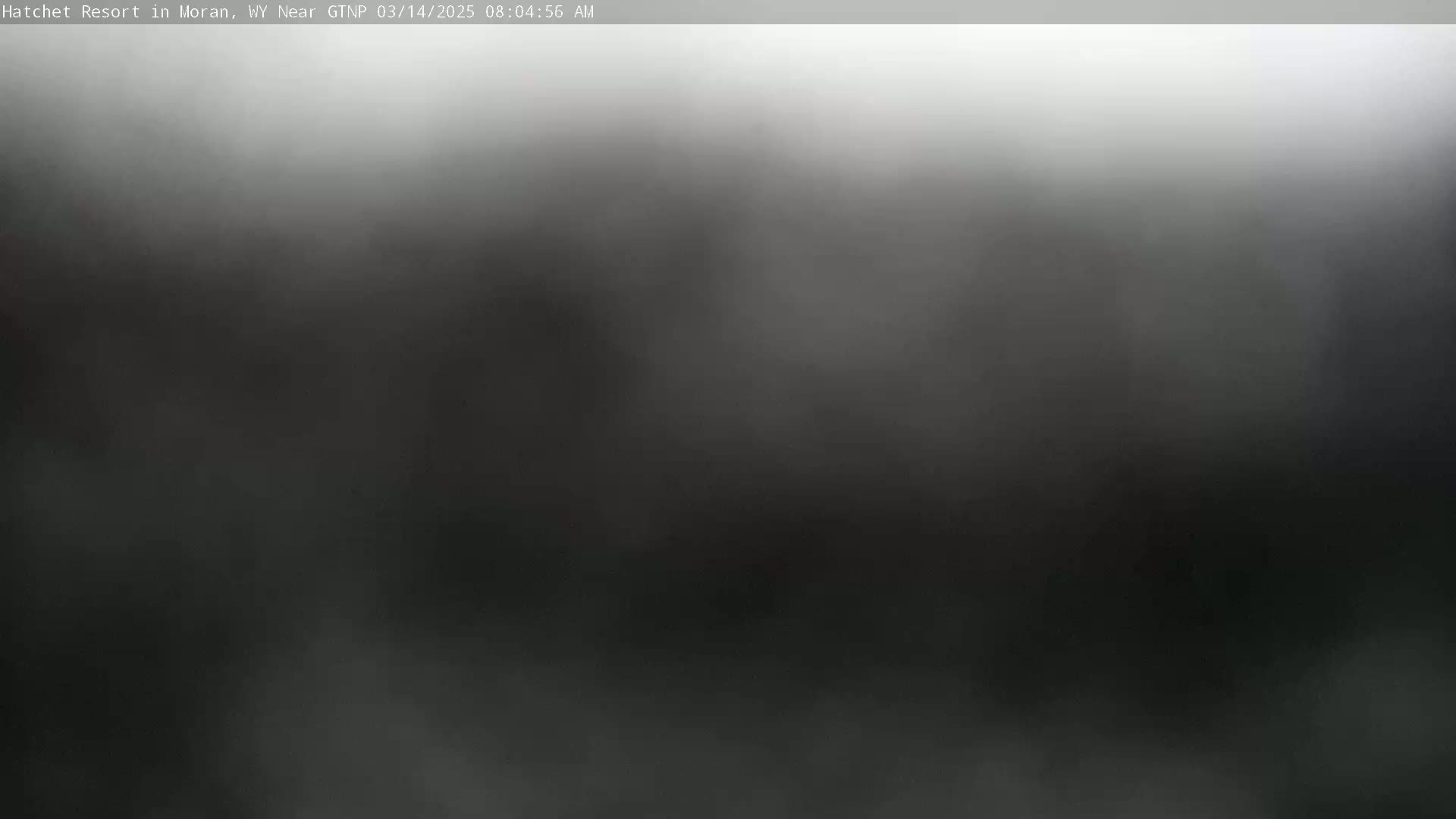 A blurry, dark gray image shows an outdoor scene obscured by heavy fog or mist.