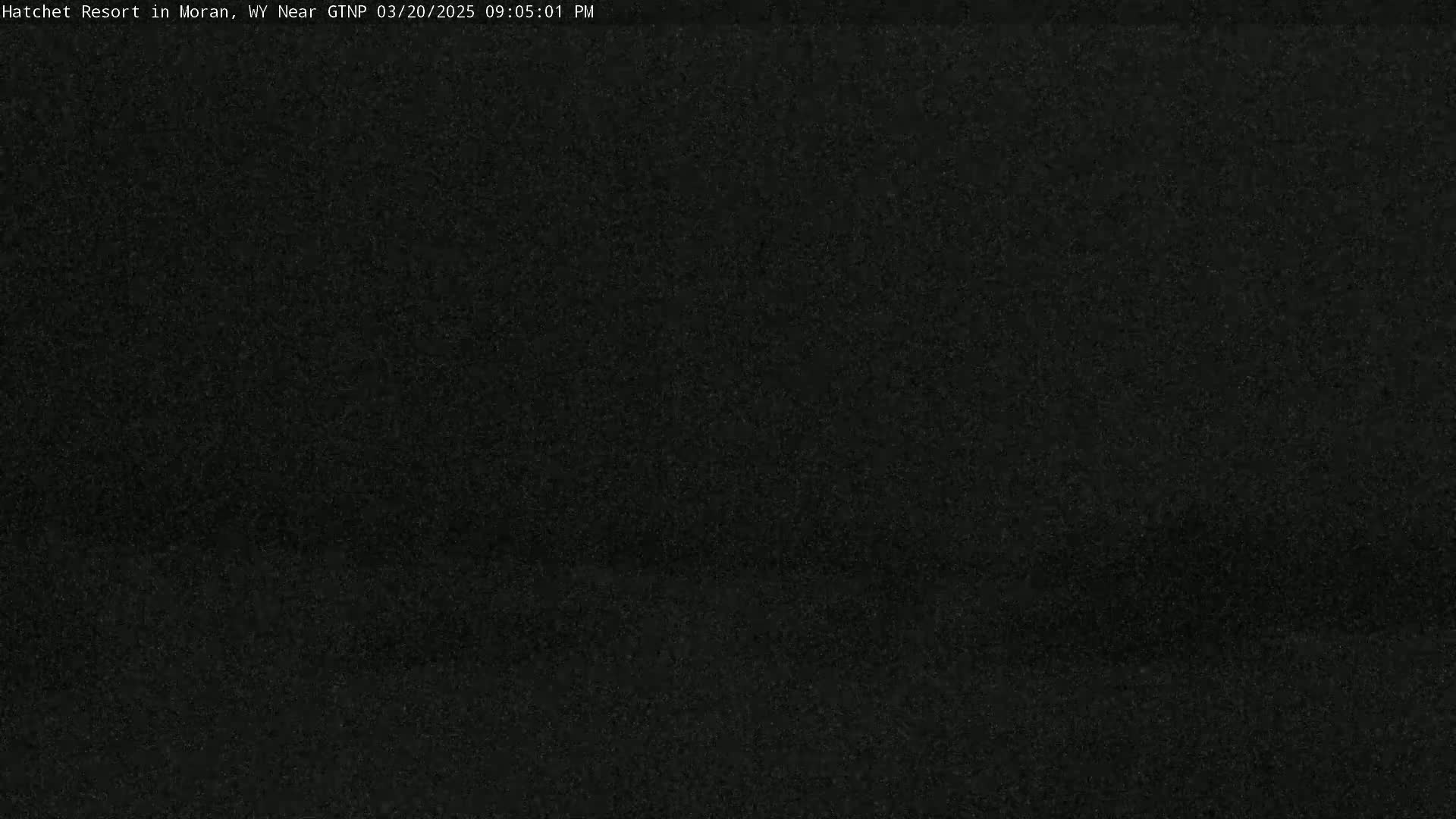 A dark, grainy image shows a completely black view, possibly due to nighttime or poor visibility.
