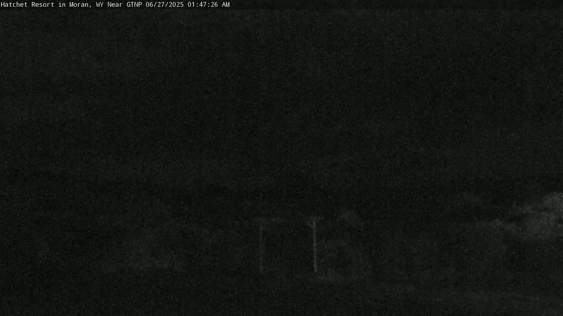 A dark, nighttime scene shows a mostly obscured landscape with very low light.