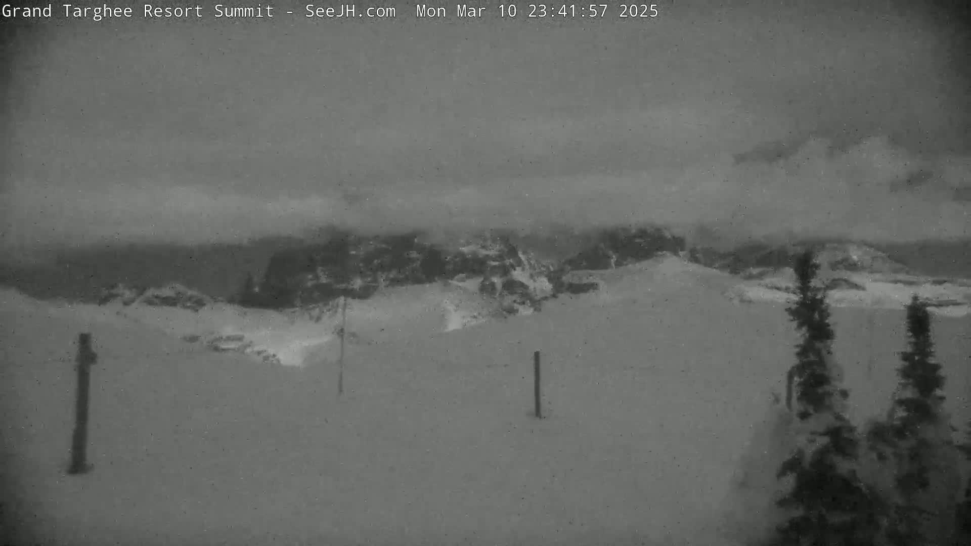 A snow-covered mountain landscape is visible under an overcast sky.