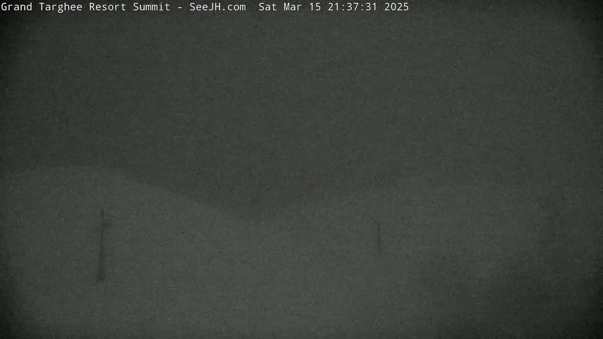 A dark, blurry image shows a nighttime, outdoor scene of a mostly obscured landscape under overcast conditions.