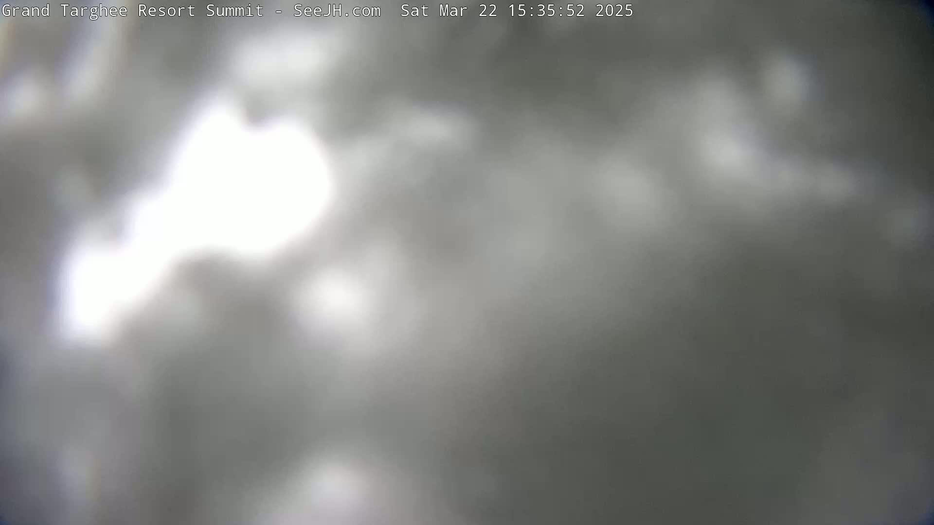 A blurry, overcast sky is visible, with some brighter areas suggesting sunlight partially obscured by clouds.