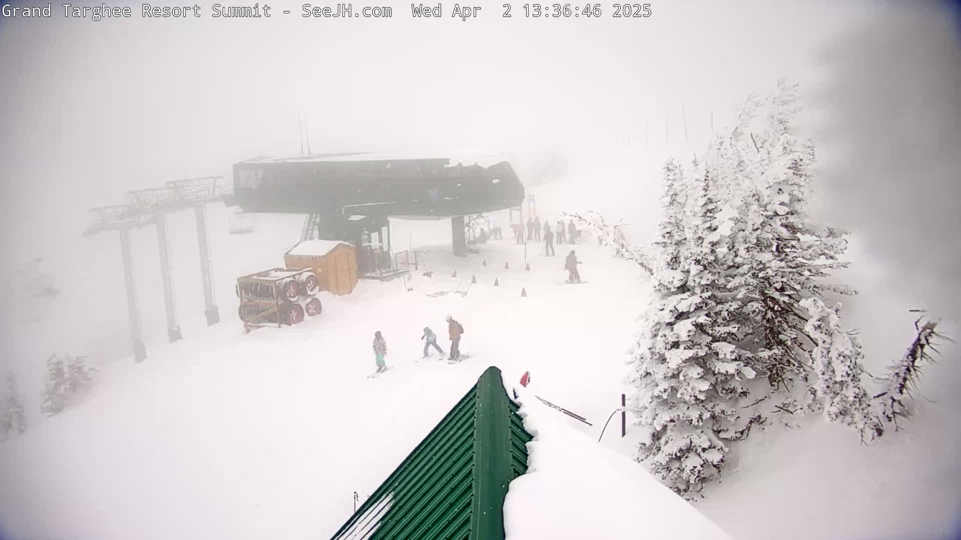 A snowy ski resort scene is visible in heavy fog, with several people skiing or snowboarding near a ski lift.