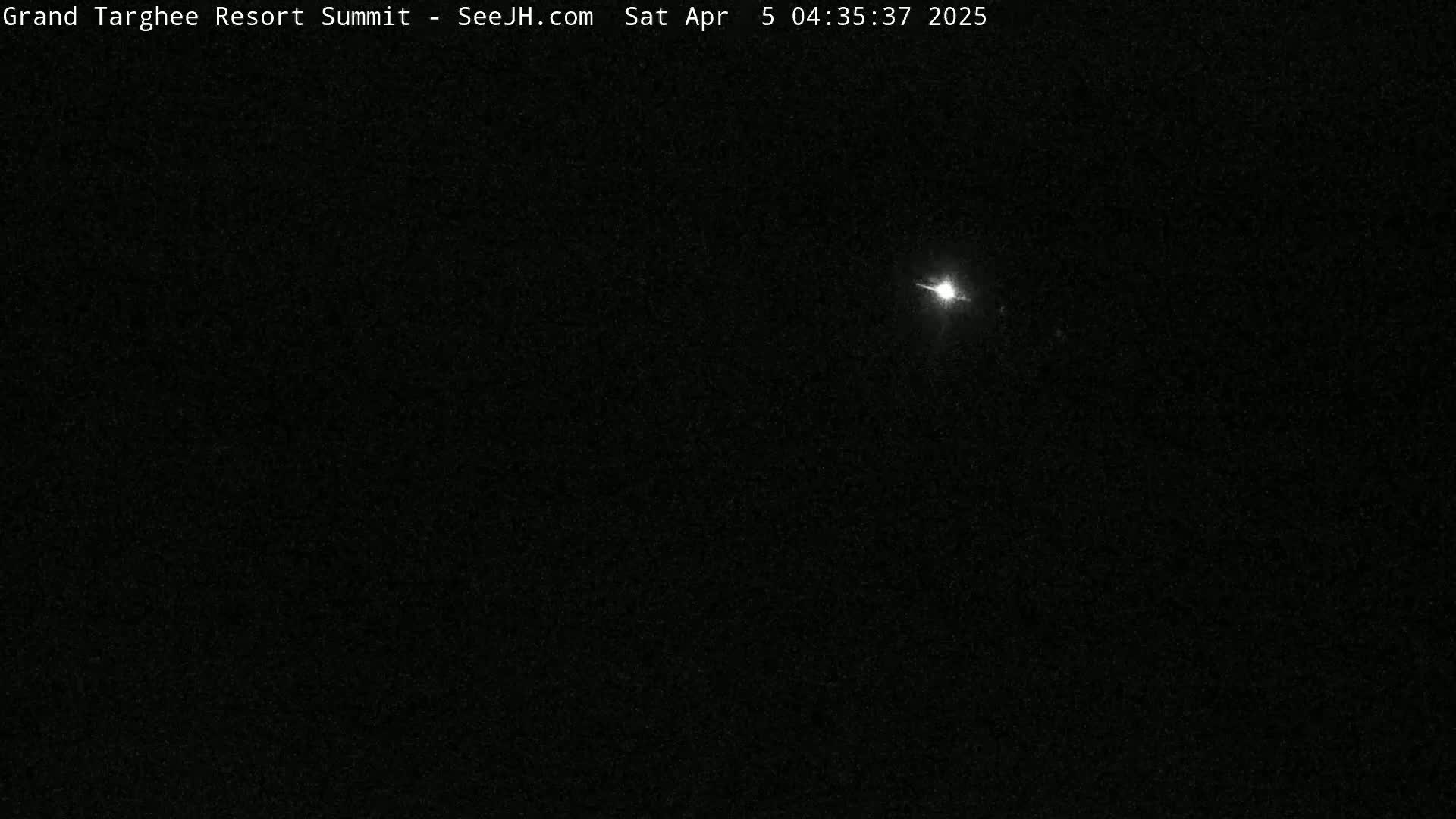 A bright light streaks across a dark, night sky.