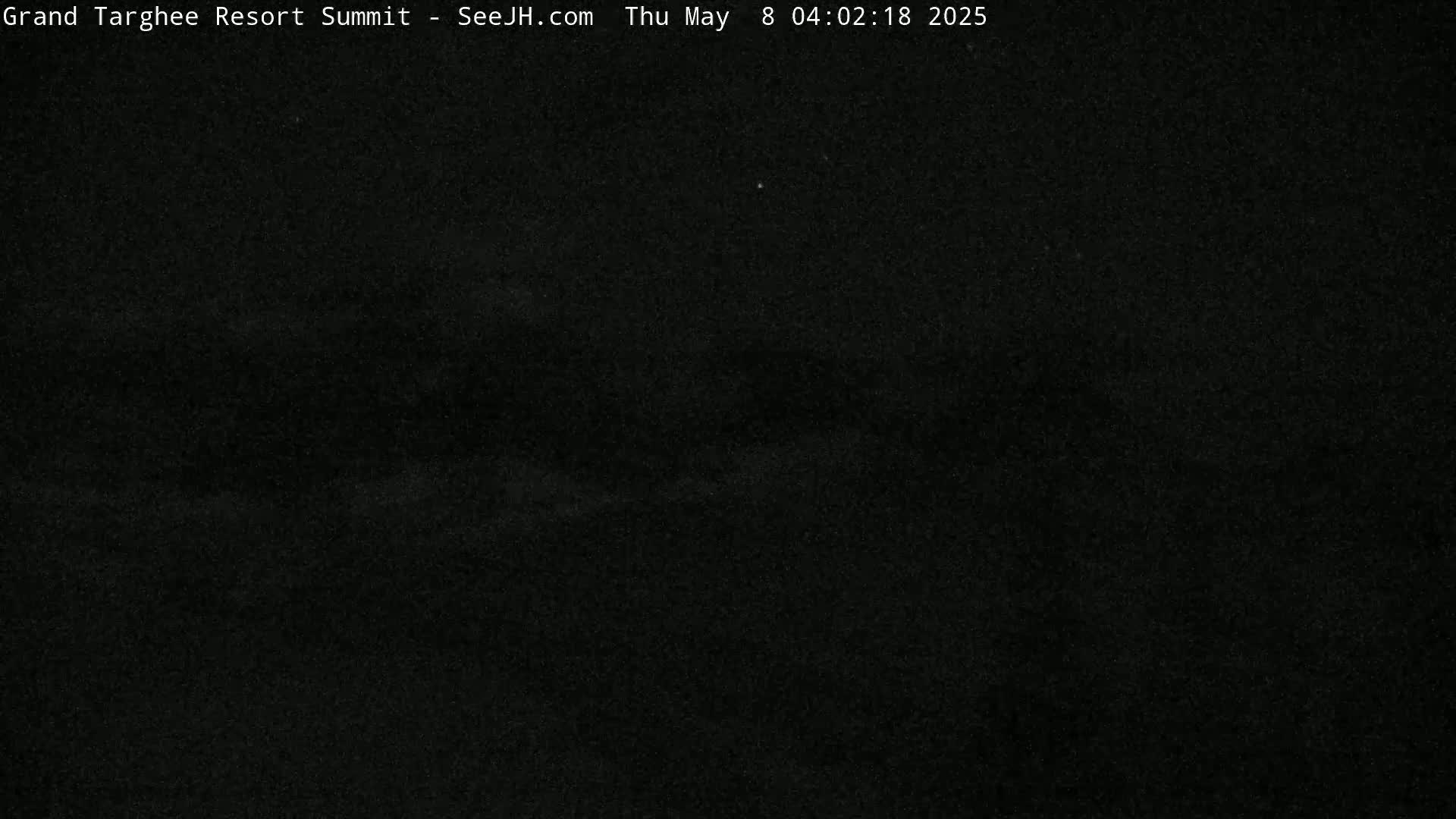 A dark, nighttime scene shows a mostly black sky with a few faint, indistinct light sources.