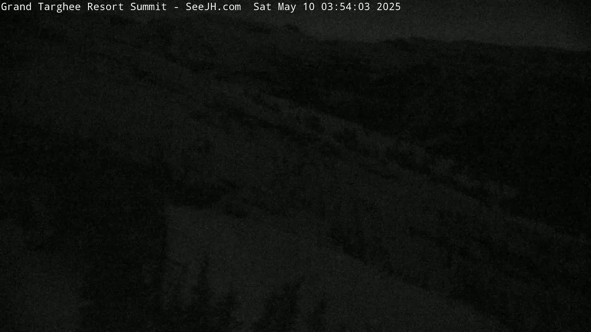 A dark, nighttime view of a mountainous landscape.