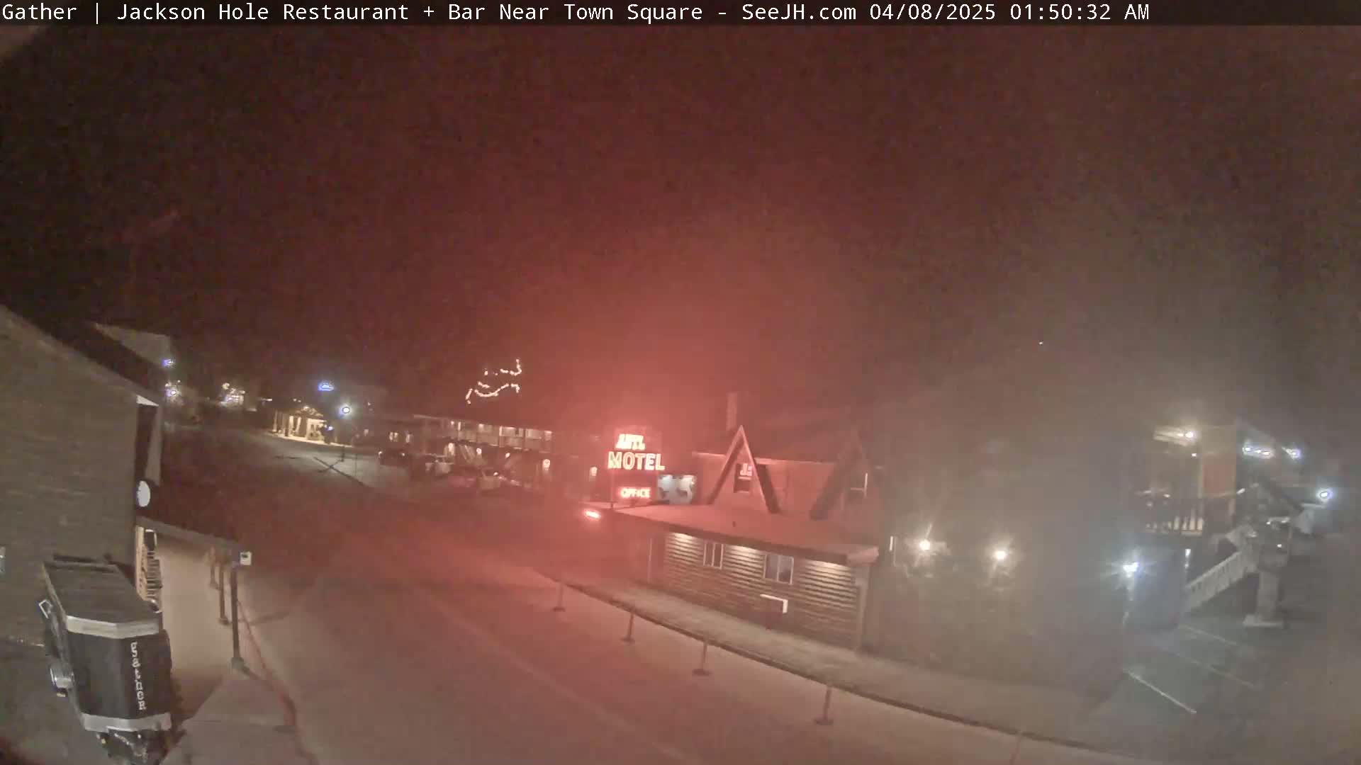A nighttime, hazy view of a motel and street scene.