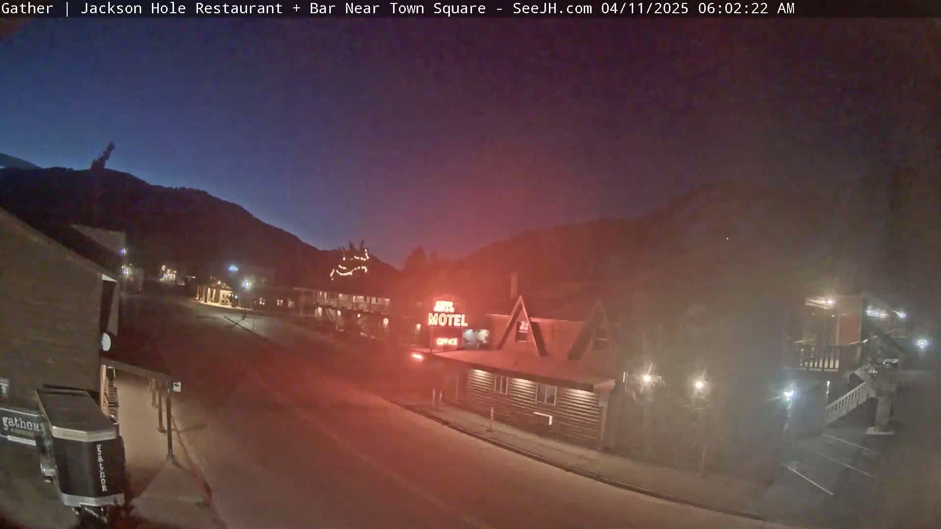 A nighttime street scene shows a motel and other buildings under a dark, clear sky.