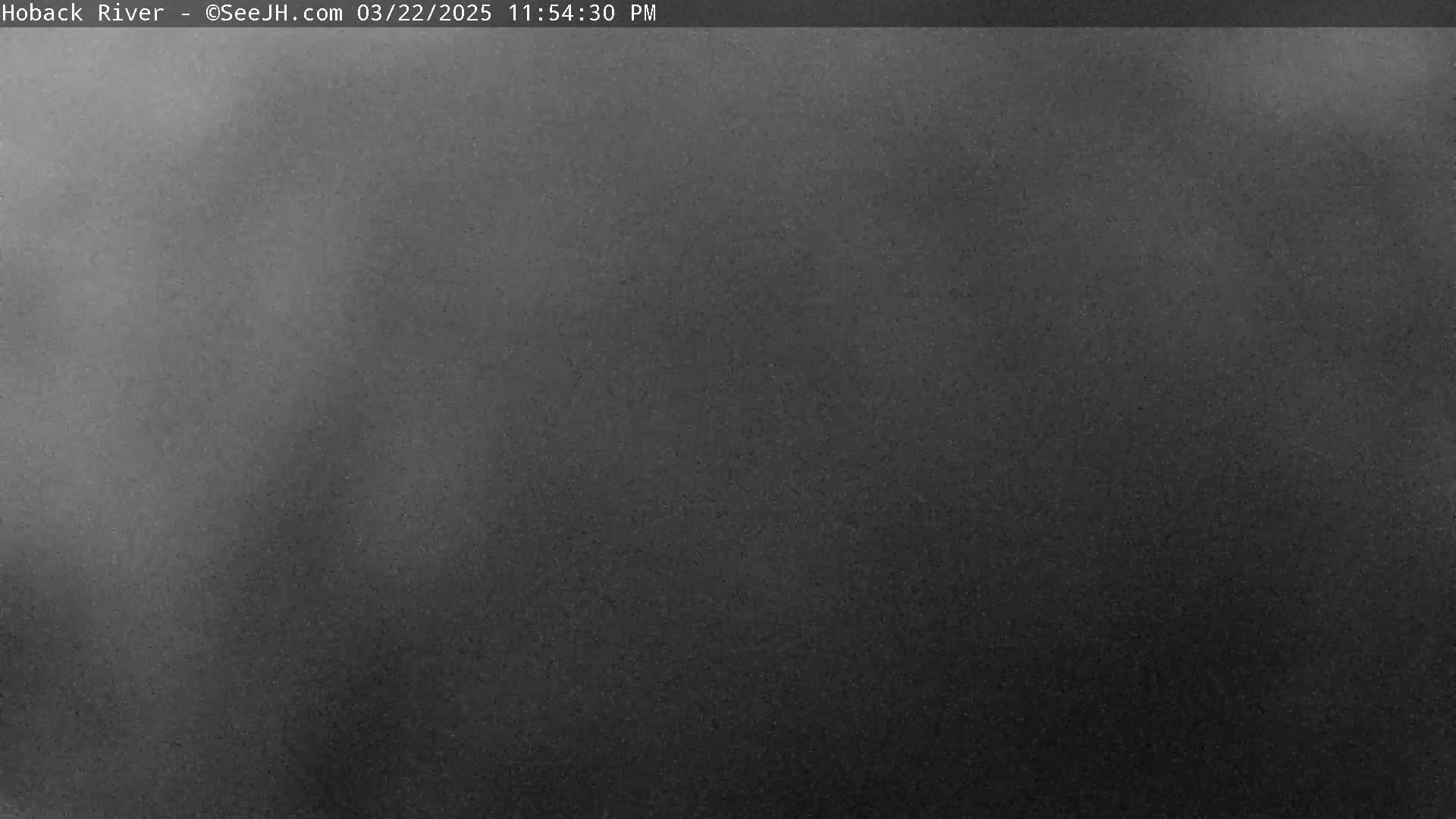 A dark gray, grainy image shows an overcast sky at night.