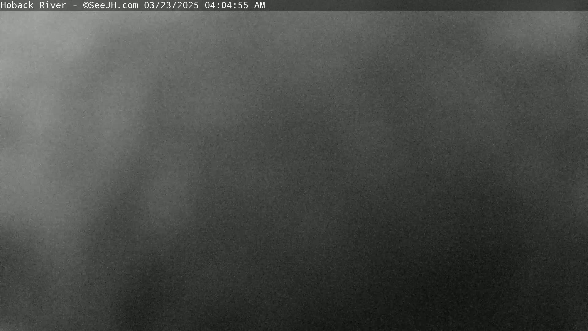 A dark, hazy image shows an overcast sky at night.