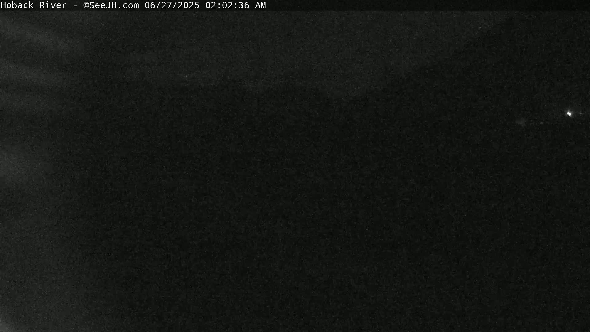 A dark, nighttime view of a mostly obscured landscape.