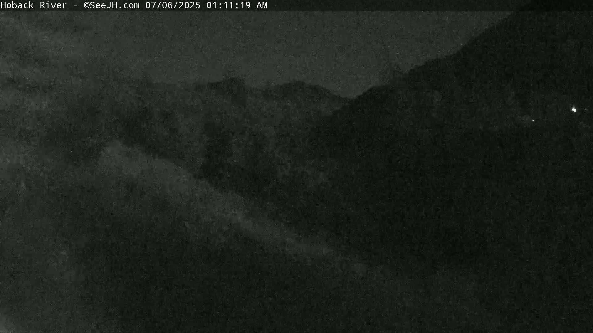 A nighttime, low-light view of dark, mountainous terrain.
