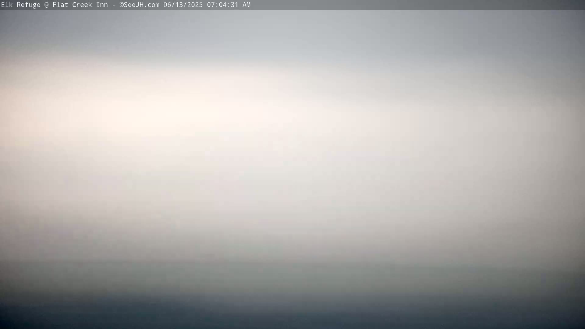 A hazy, overcast sky blends into a dark, indistinct horizon.