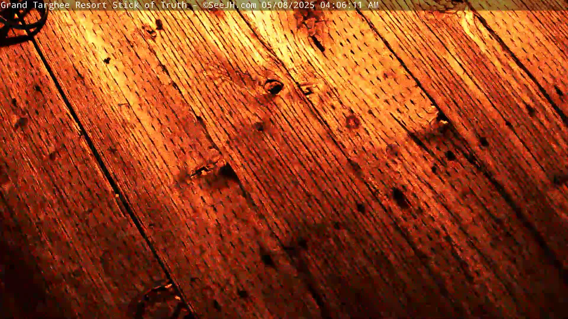 A close-up view shows a diagonally oriented, reddish-brown wooden surface.