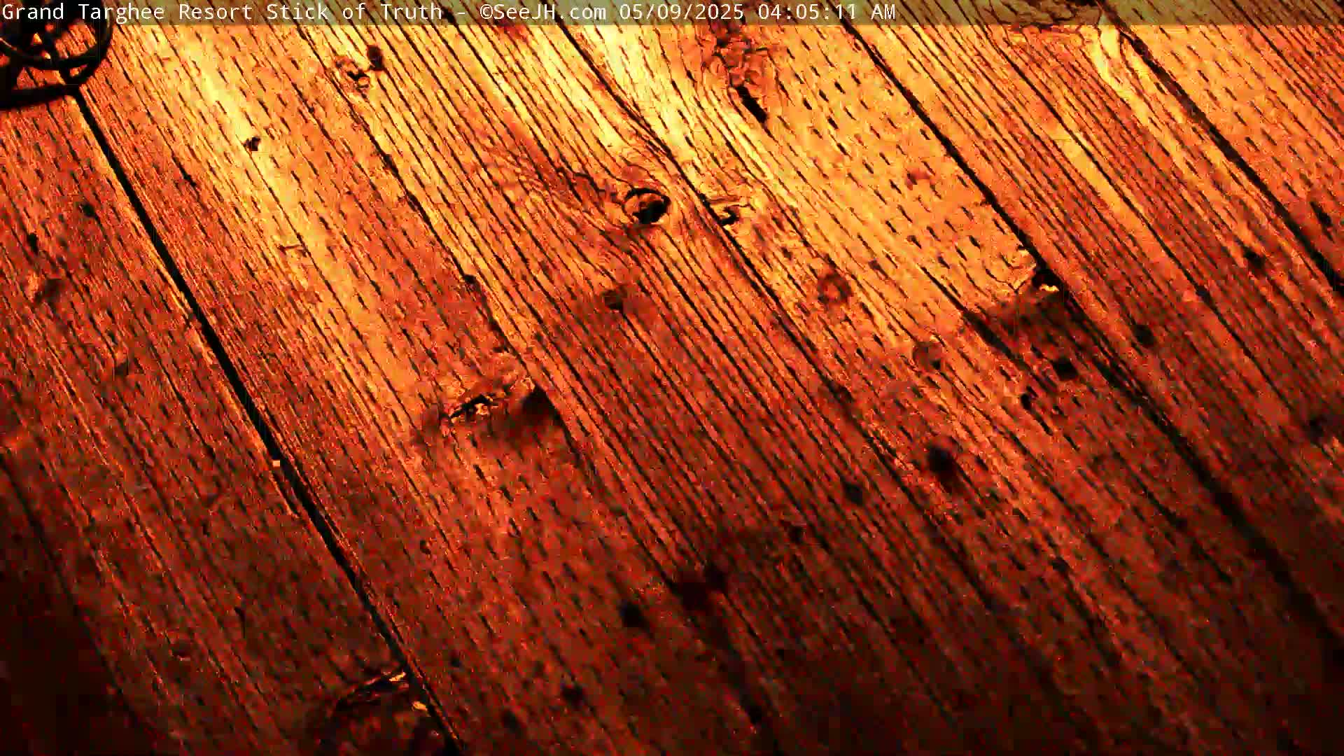 A close-up view shows diagonal, reddish-brown wood planks.