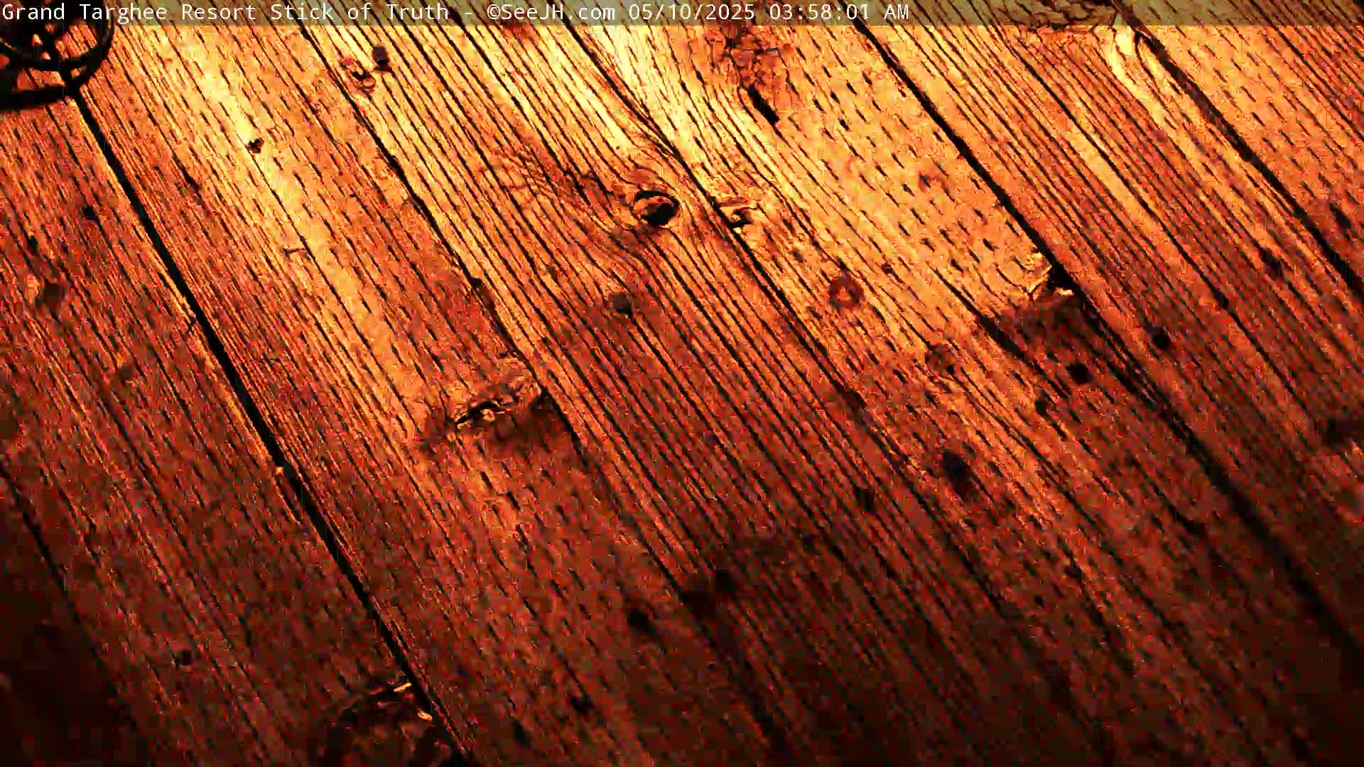 A close-up view shows weathered, reddish-brown wooden planks running diagonally across the frame.