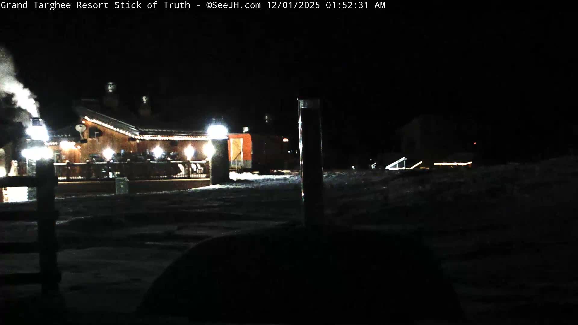 A clear, cold, snowy night scene features a brightly lit lodge with smoke rising from its chimney, illuminating the surrounding snow-covered ground.