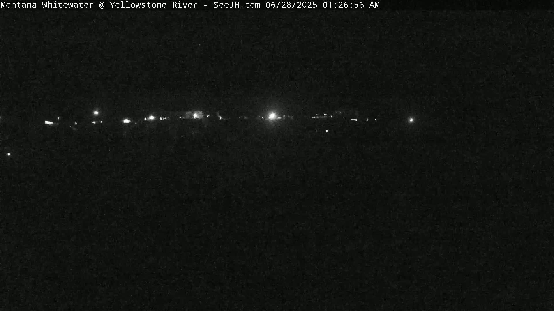 A nighttime long shot shows a dark landscape with a few distant lights.