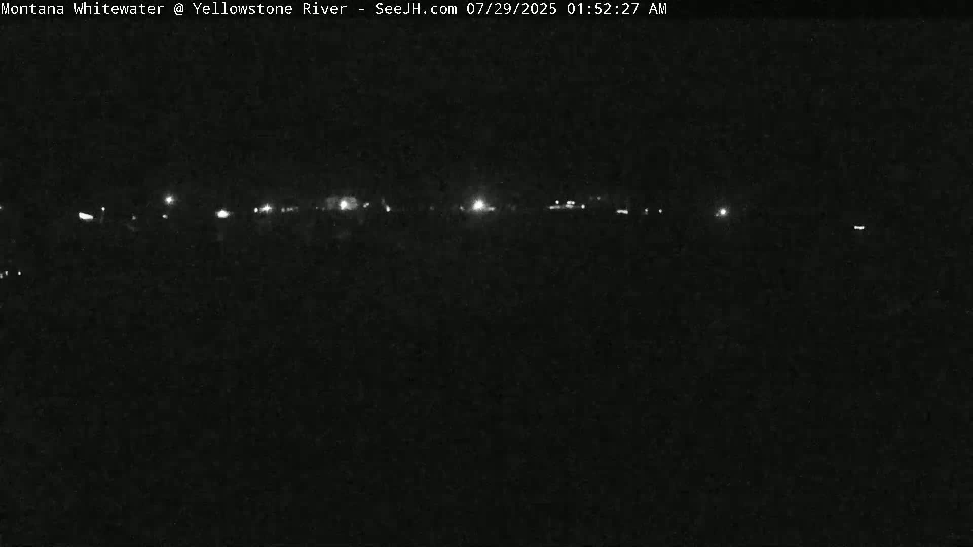 A nighttime long shot shows a line of faint lights in the distance against a dark, possibly overcast sky.