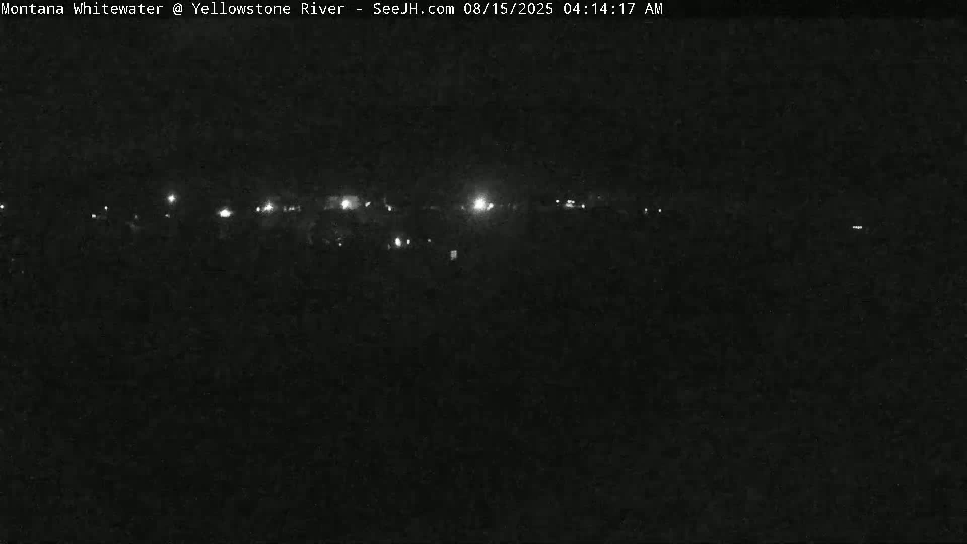 A nighttime long shot shows a line of faint lights in the distance against a dark, possibly overcast sky.