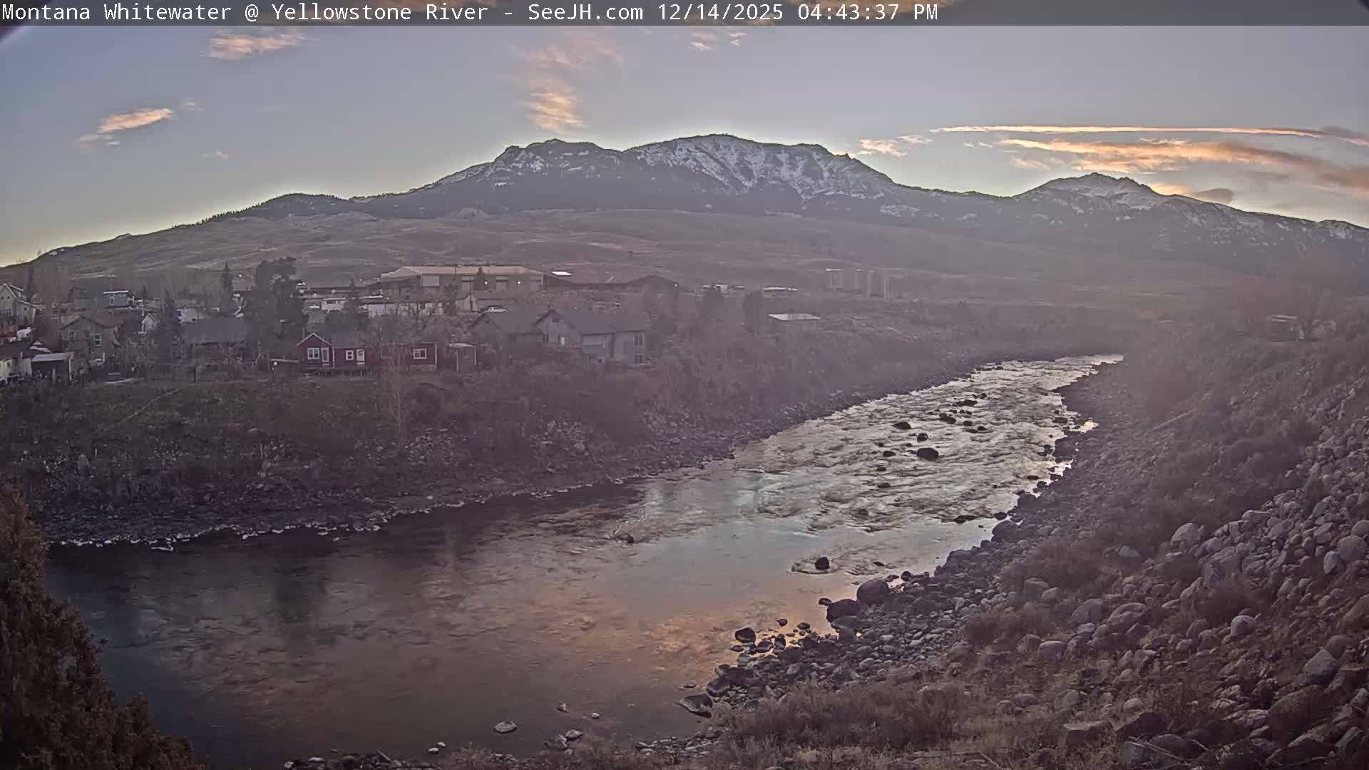 The image captures a dark night scene with numerous scattered lights illuminating a distant area, under clear weather conditions.