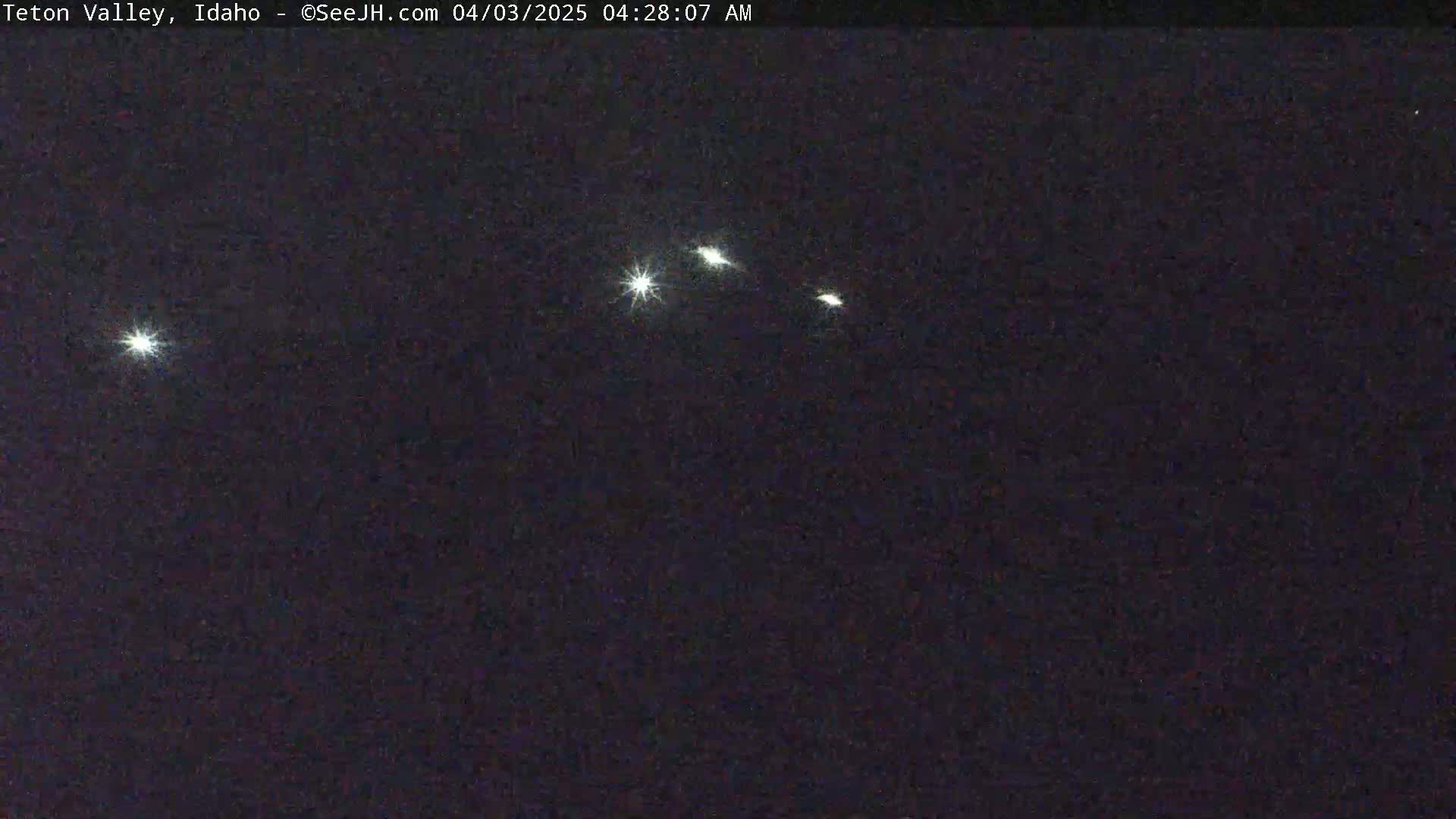 Four bright lights are visible in the night sky.