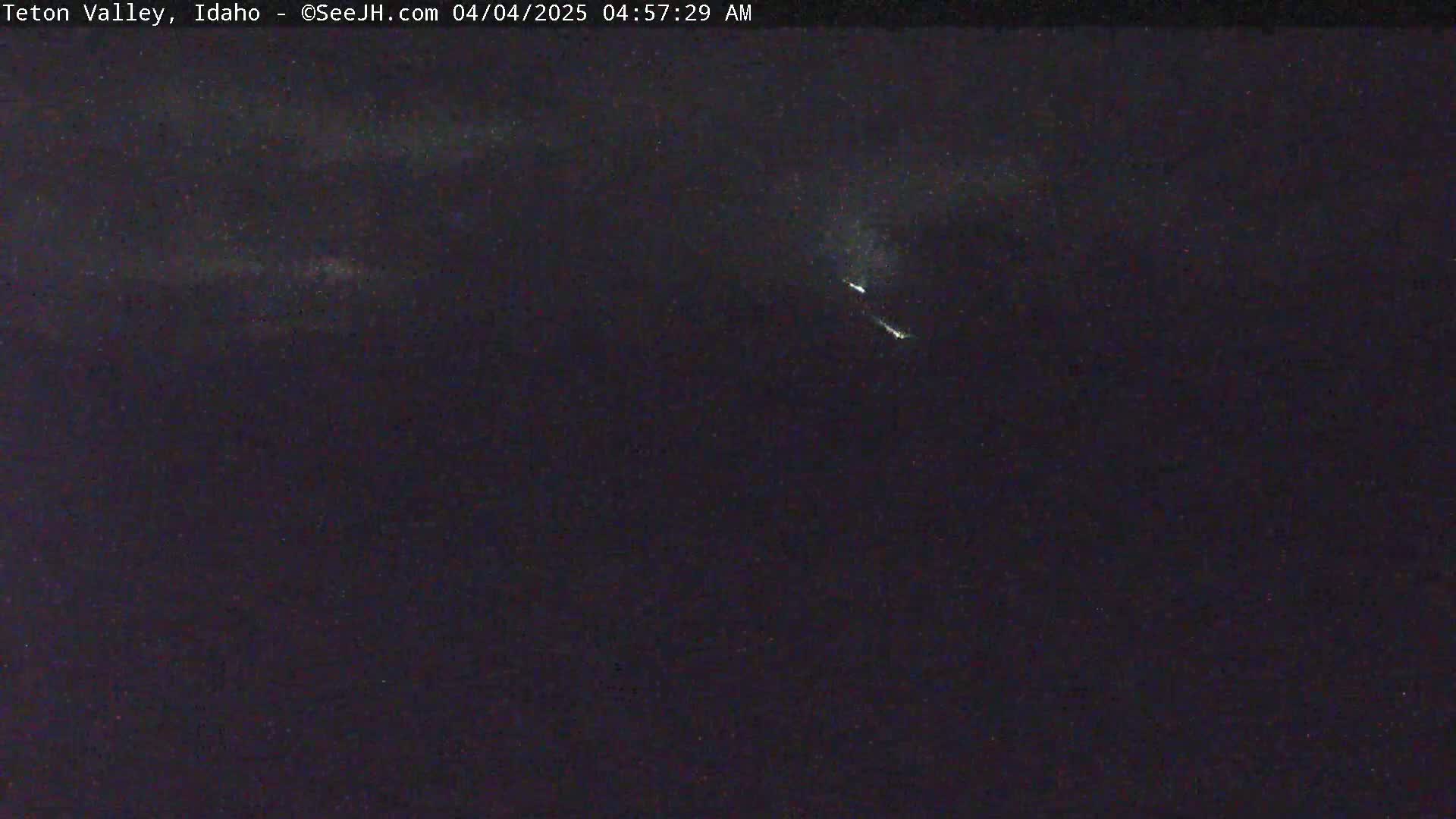 A nighttime outdoor image shows two bright streaks across a dark sky.