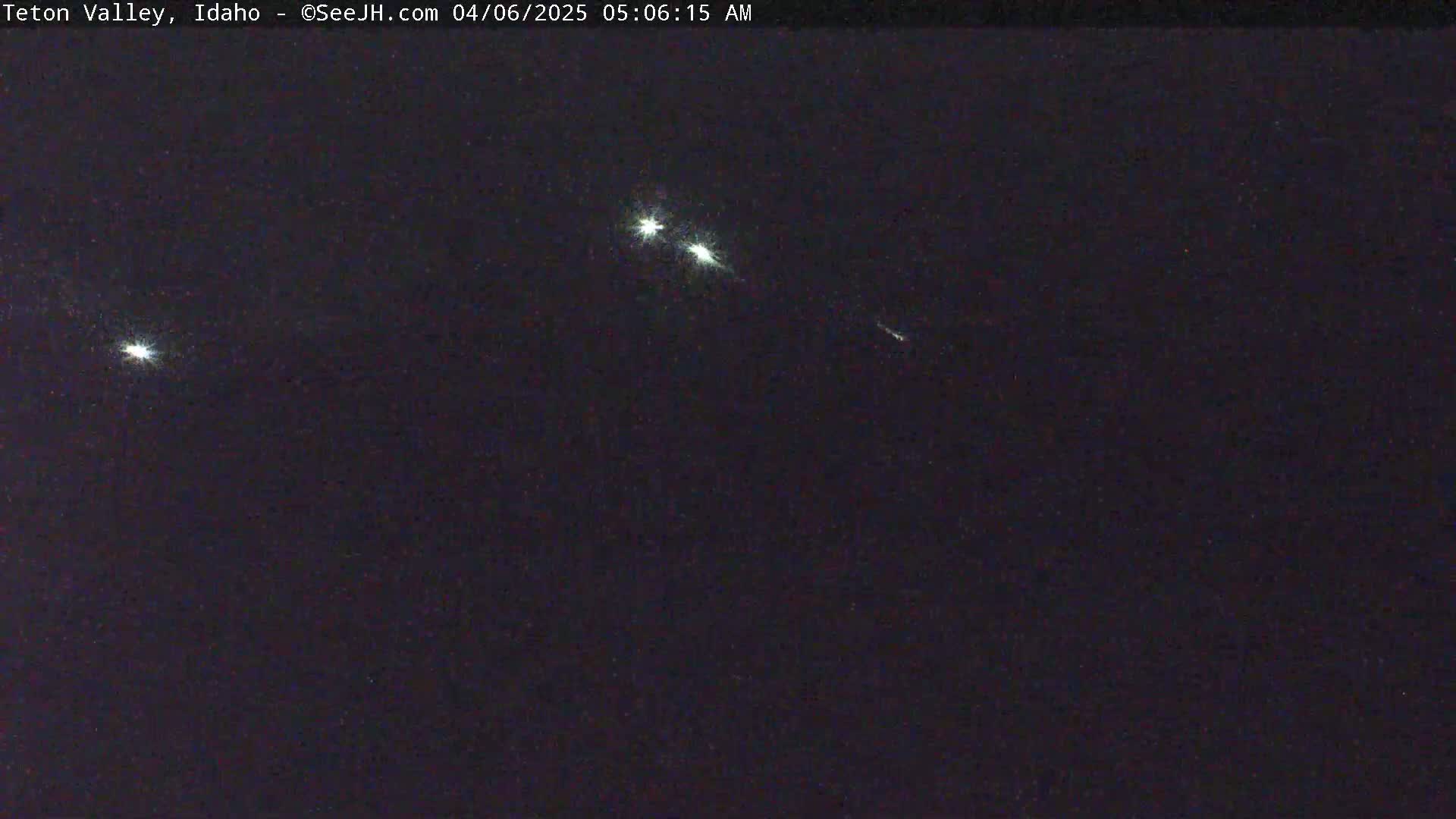 Several bright meteors streak across a dark night sky.