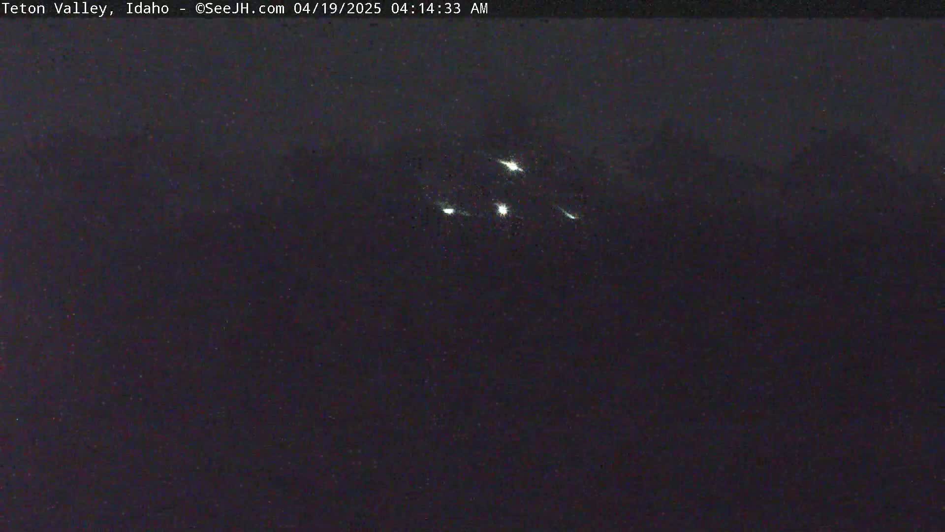 A nighttime outdoor image shows several bright streaks of light in the dark sky.