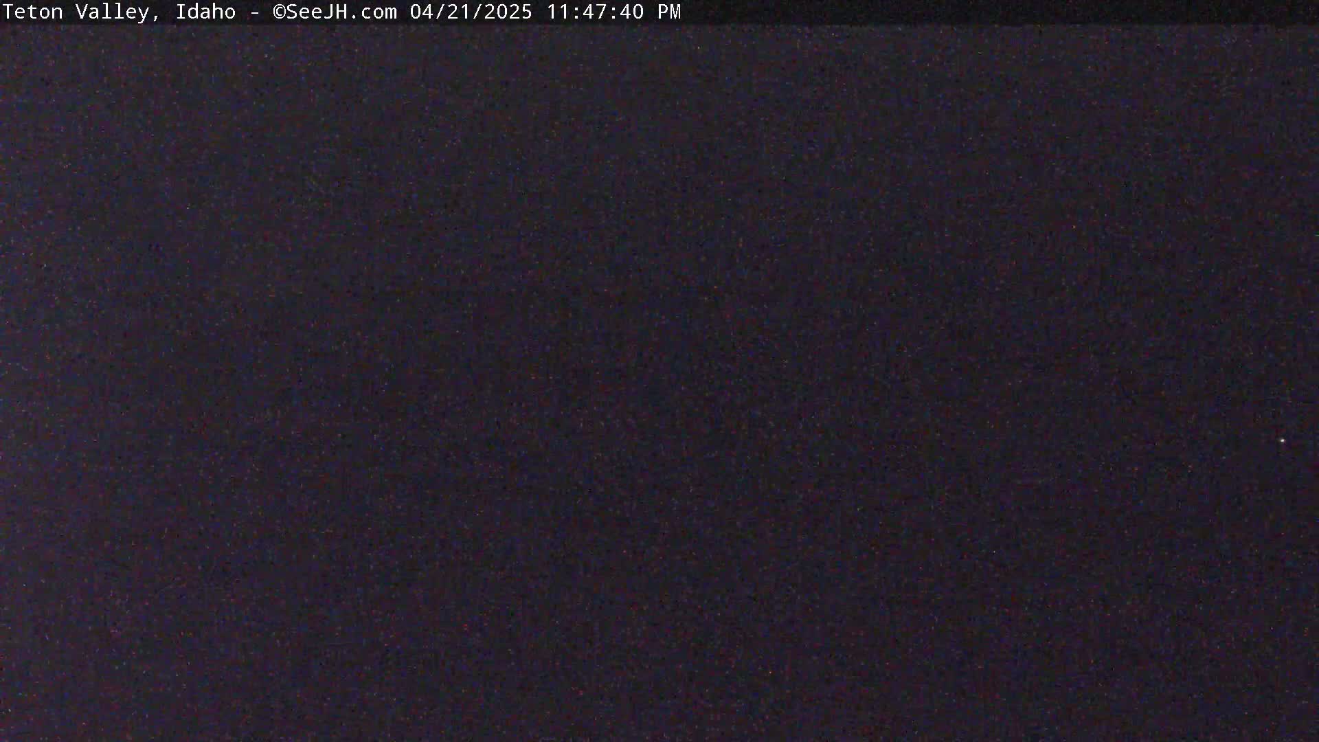 A dark, nighttime image shows a mostly uniform black field with subtle variations in shade.