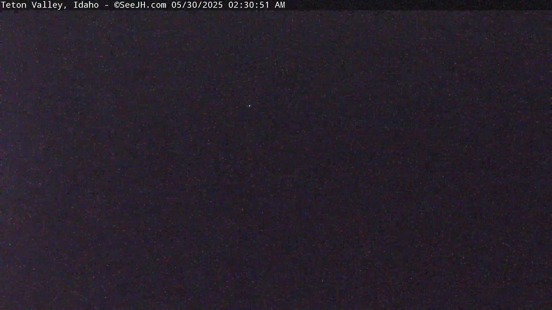 A nighttime outdoor image shows a dark sky speckled with faint light.