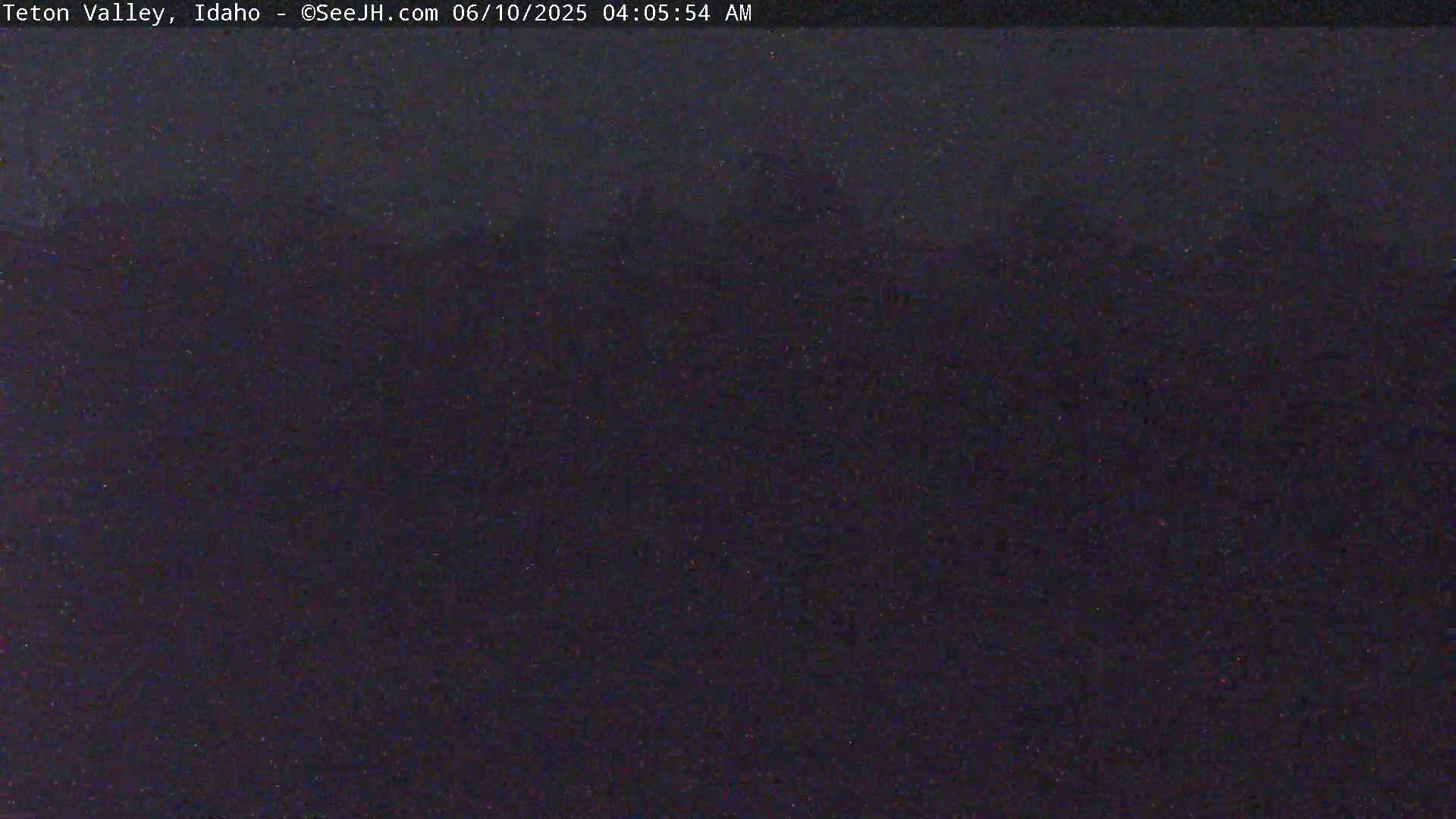 A dark, nighttime outdoor scene shows a blurry, indistinct landscape under a dark sky.