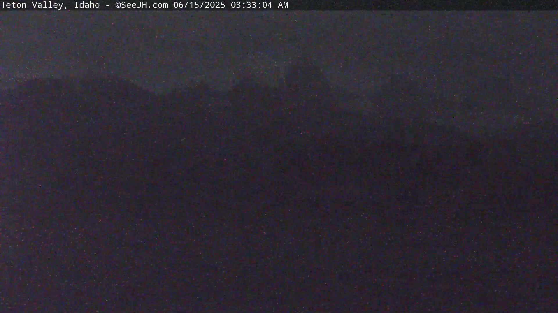 A dark, nighttime landscape is visible under a cloudy sky.