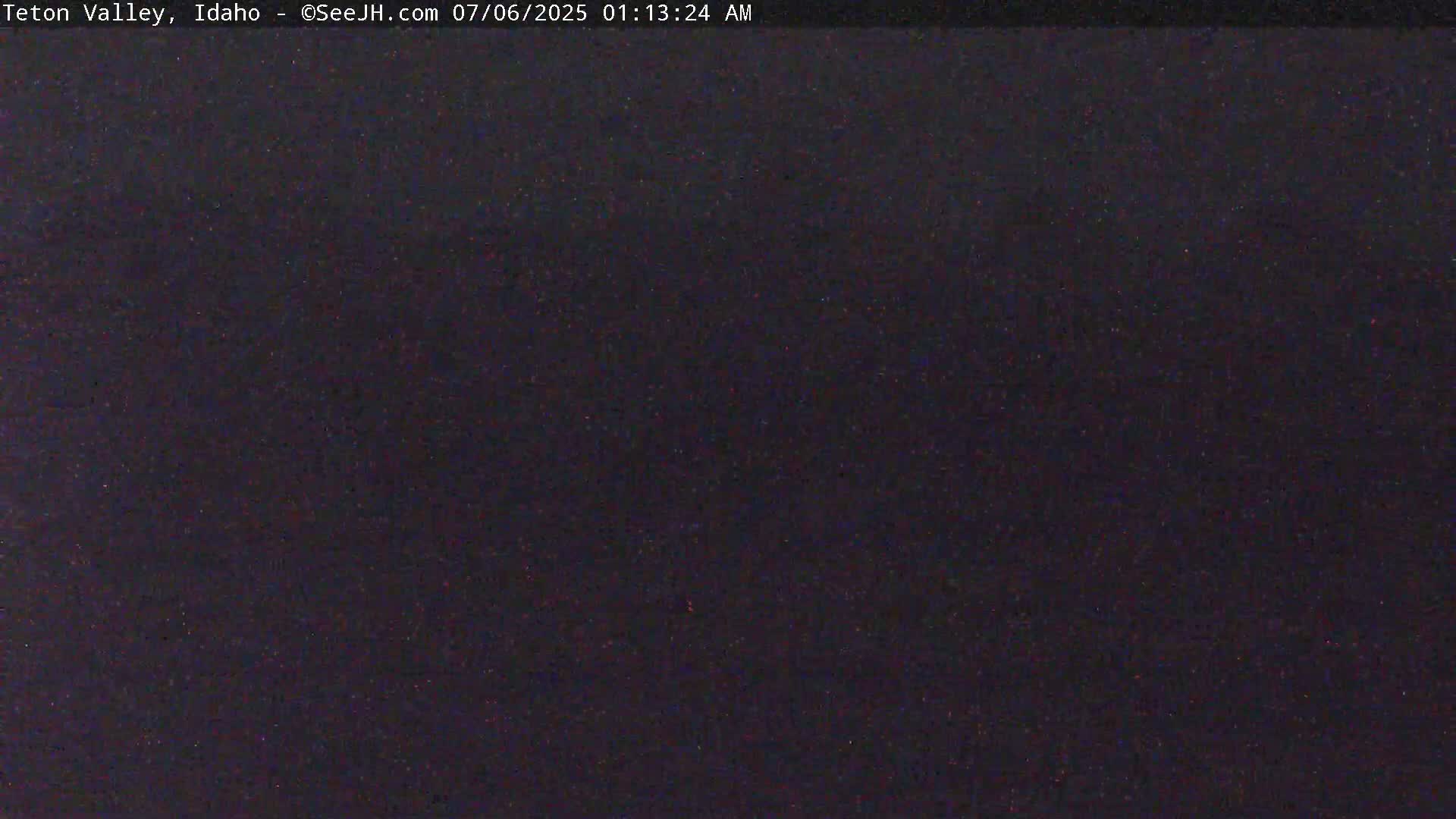 A dark, nighttime image shows a uniformly dark-colored surface with subtle variations in tone.
