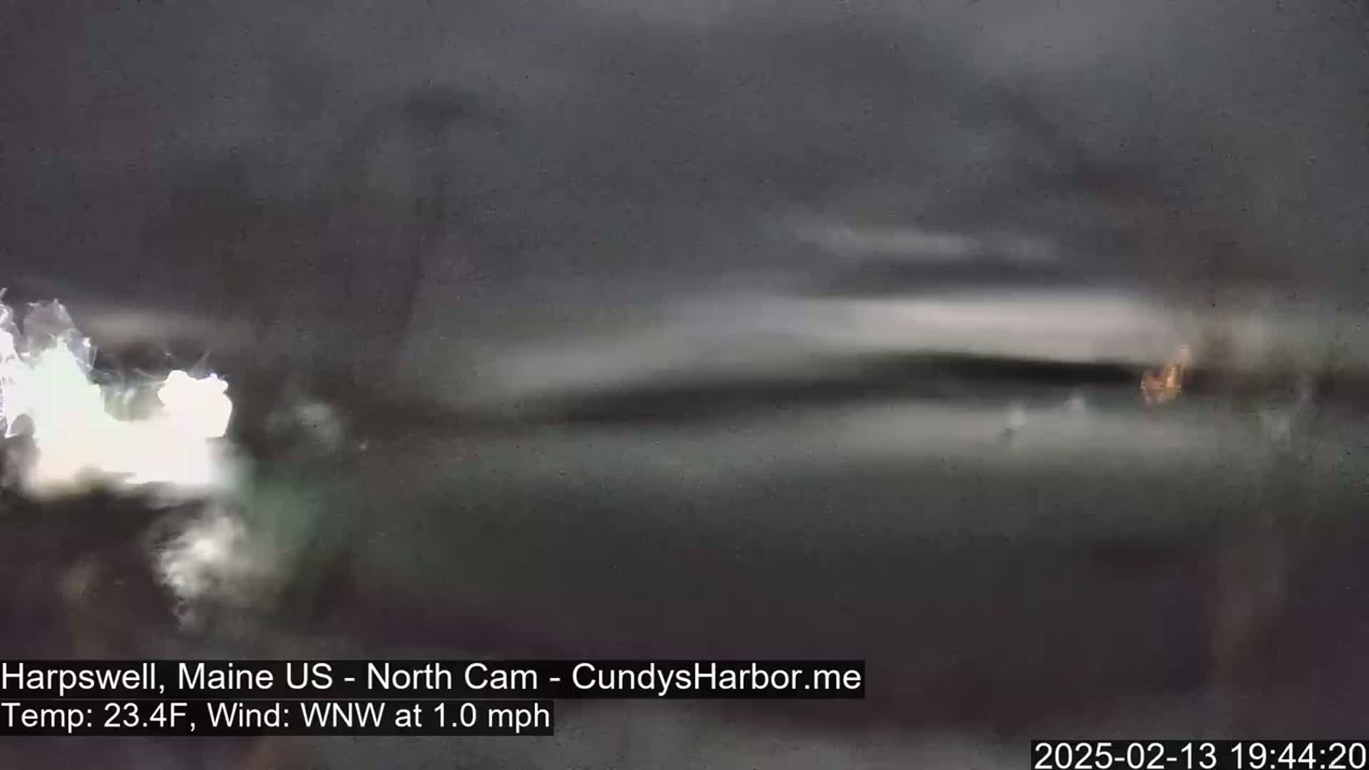 A blurry, dark image shows a body of water under a dark sky with a light wind.